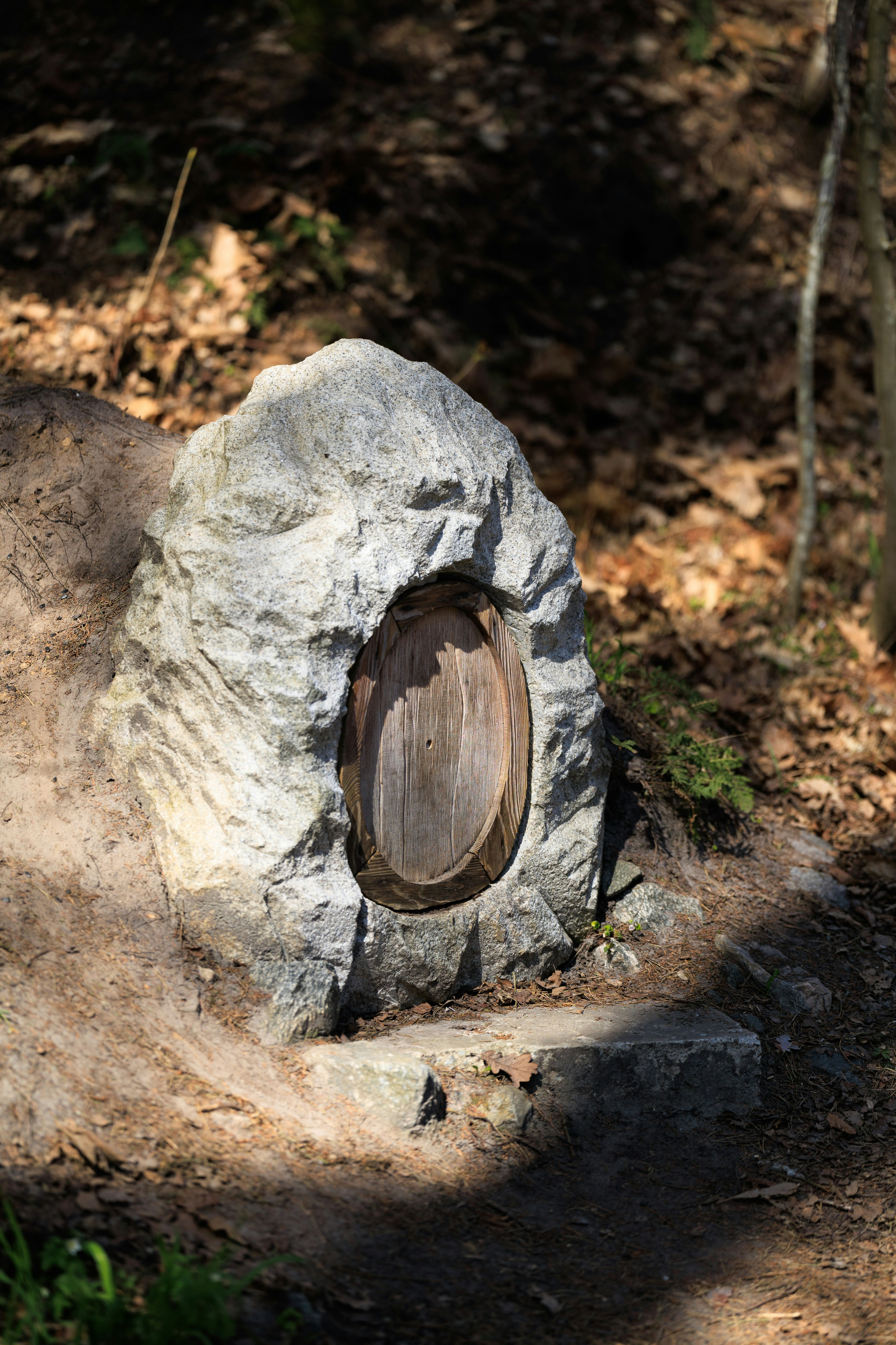 A small wooden door carved into a large rock.