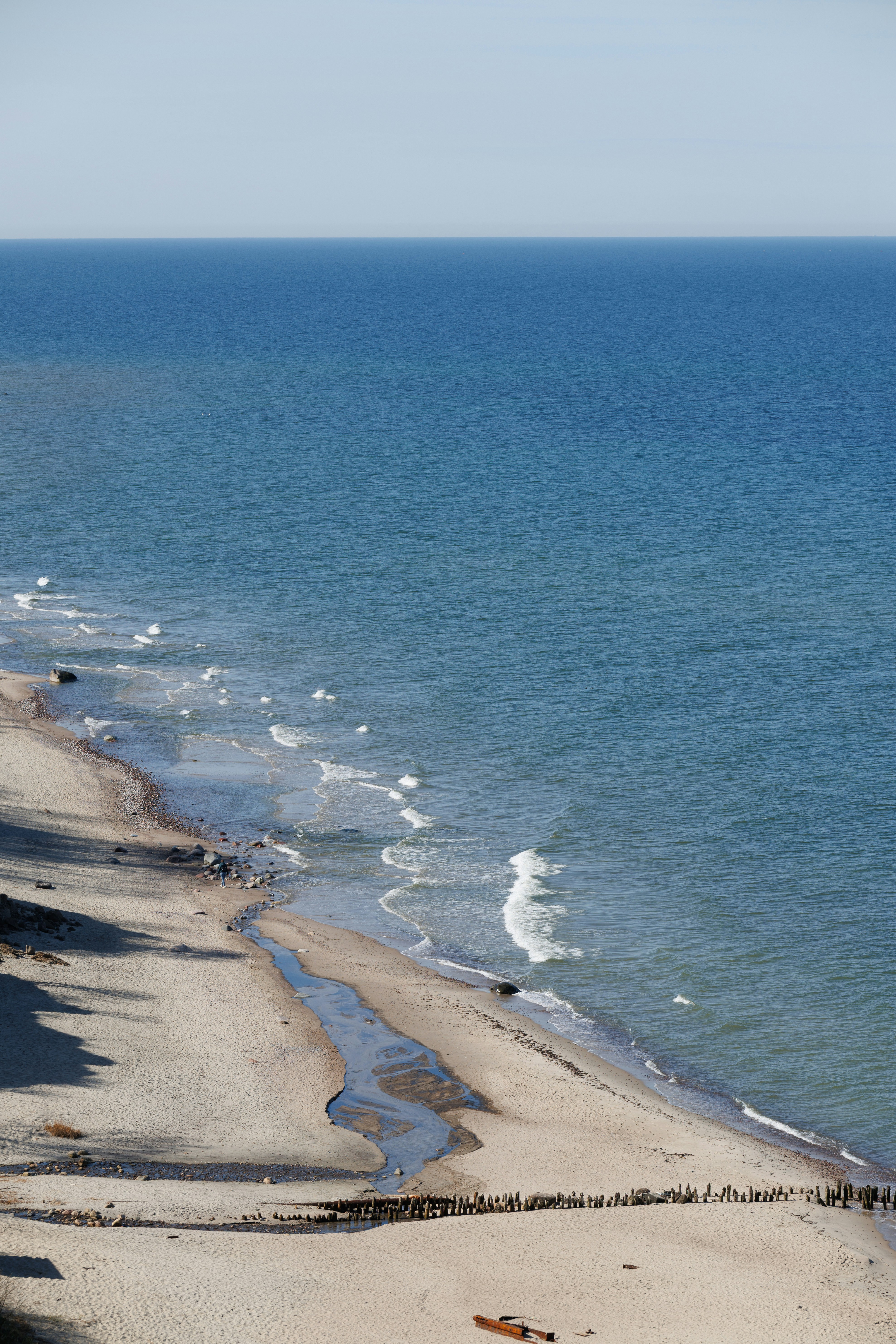 Sandy beach with gentle waves meeting the shore.