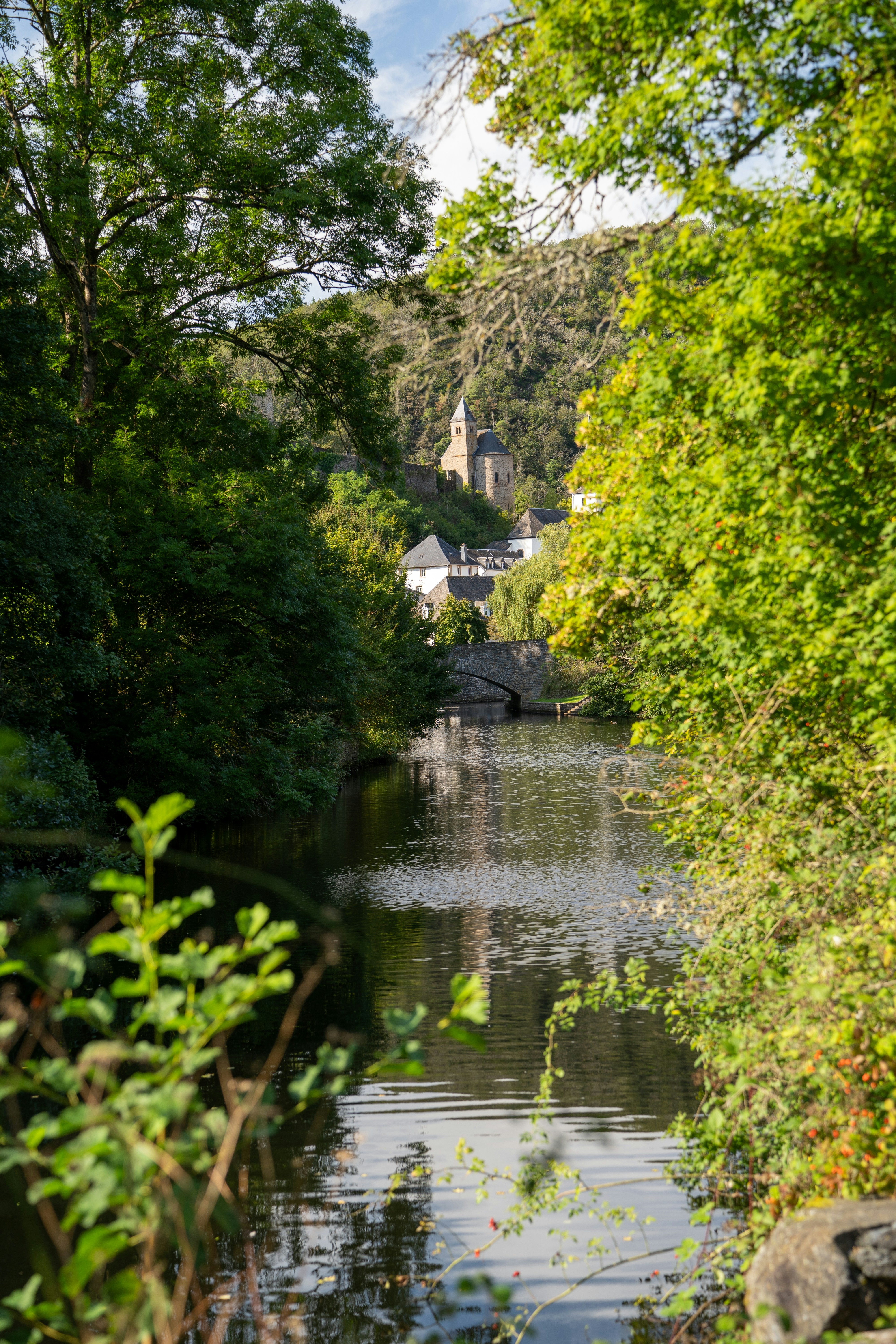 Der Fluss fließt durch ein Dorf mit einem Kirchturm.