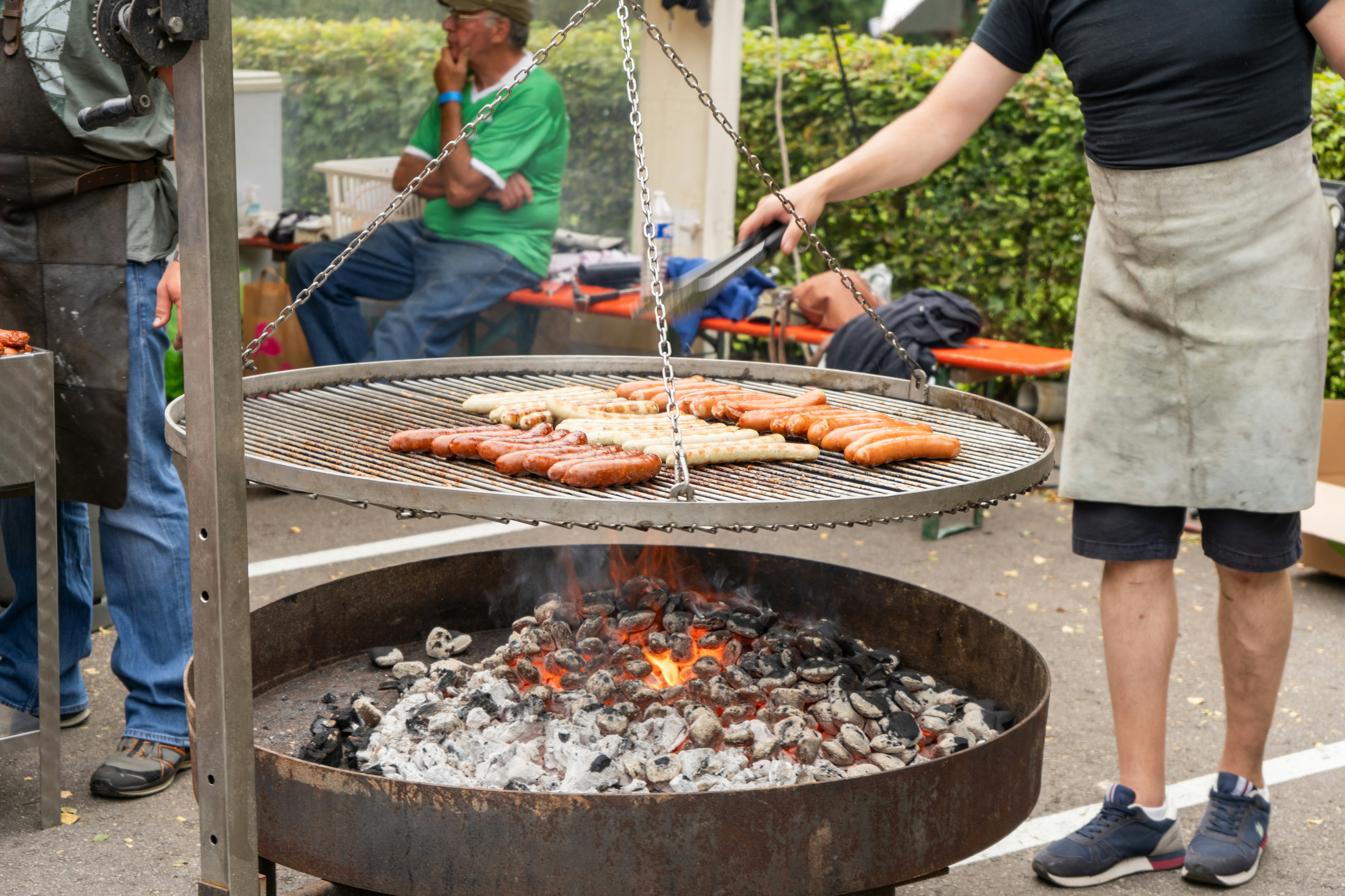 Würste, die auf einem großen Außengrill zubereitet werden