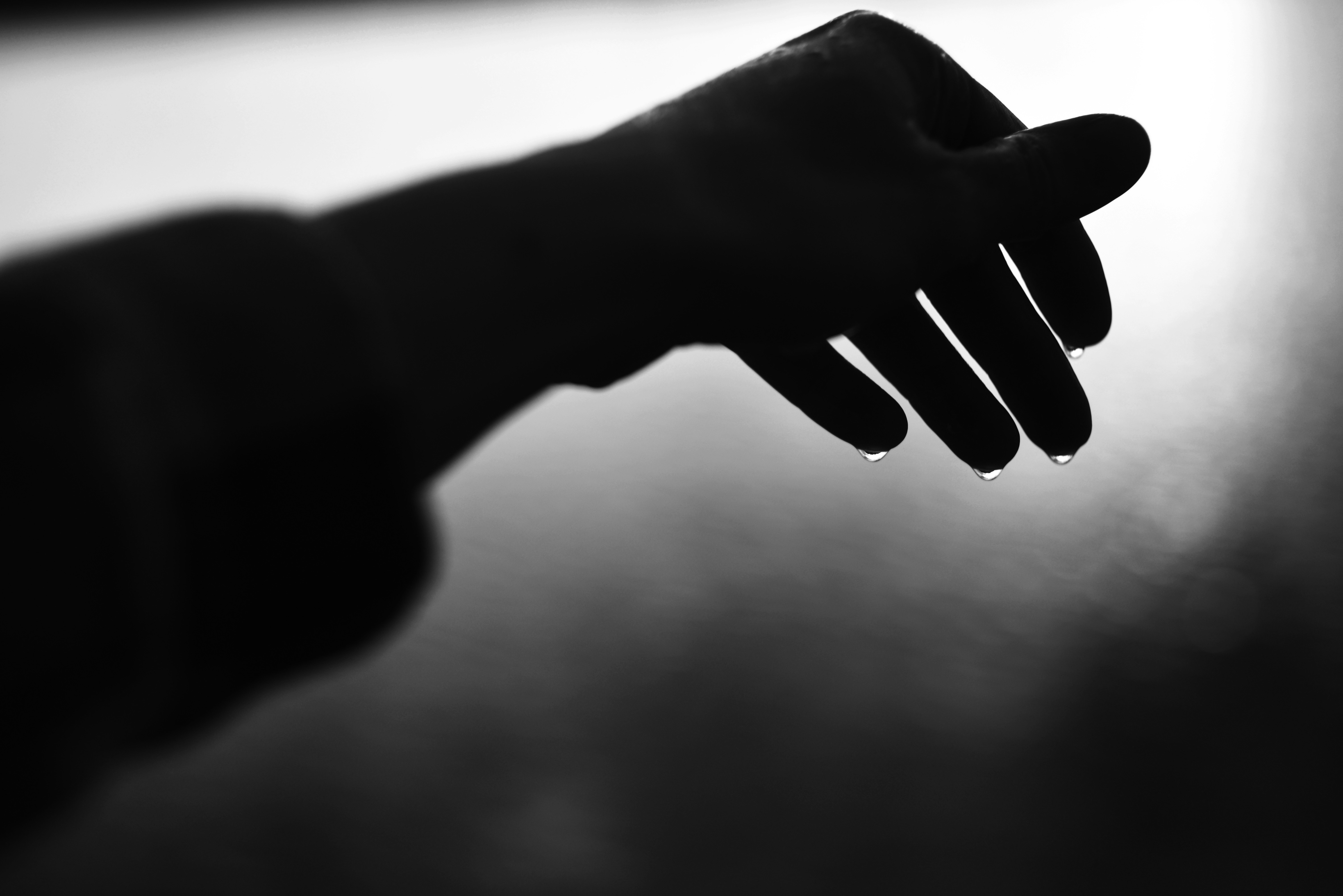 指先から水滴が落ちる手。