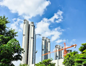 Modern skyscrapers under a bright blue sky with clouds.