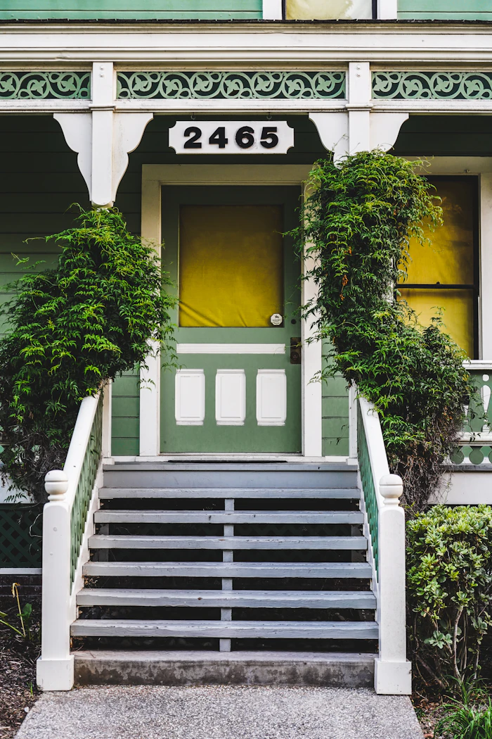 Green house with an ornate porch