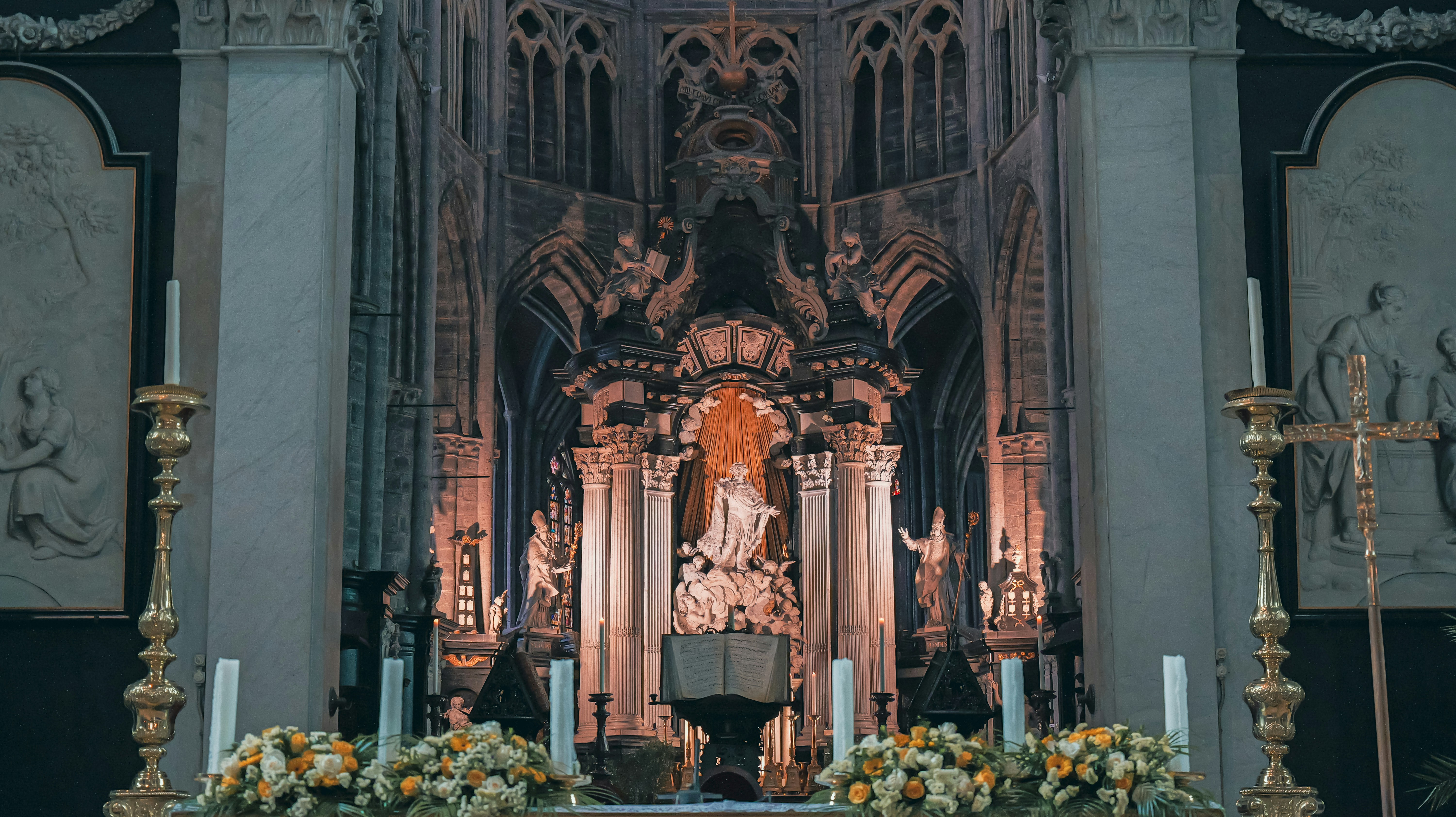 Ein kunstvoller Altar mit Kerzen und Blumen in einer Kirche.