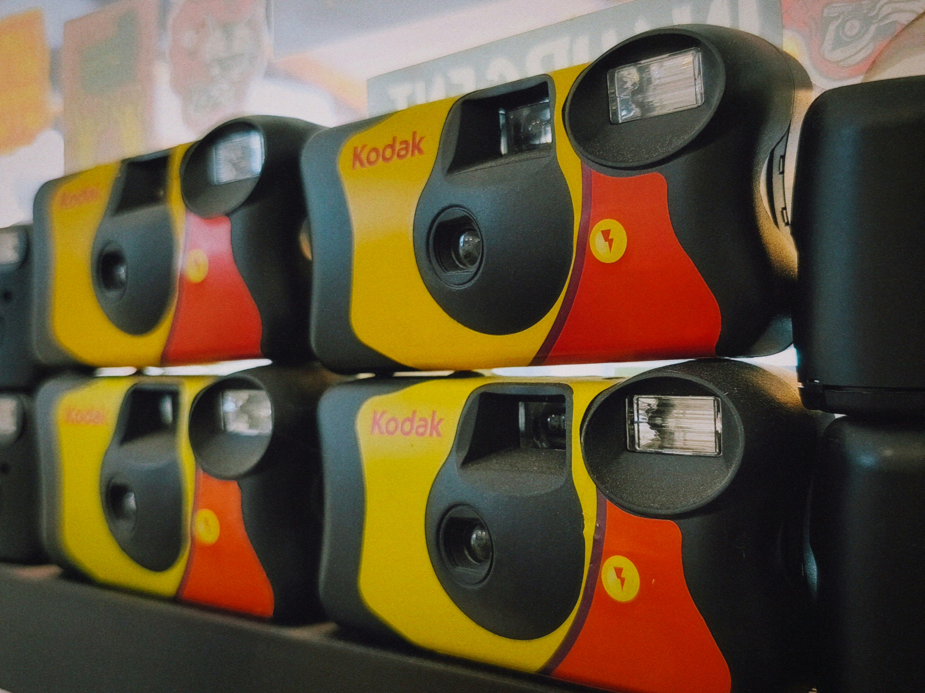 Several yellow and red kodak disposable cameras stacked.