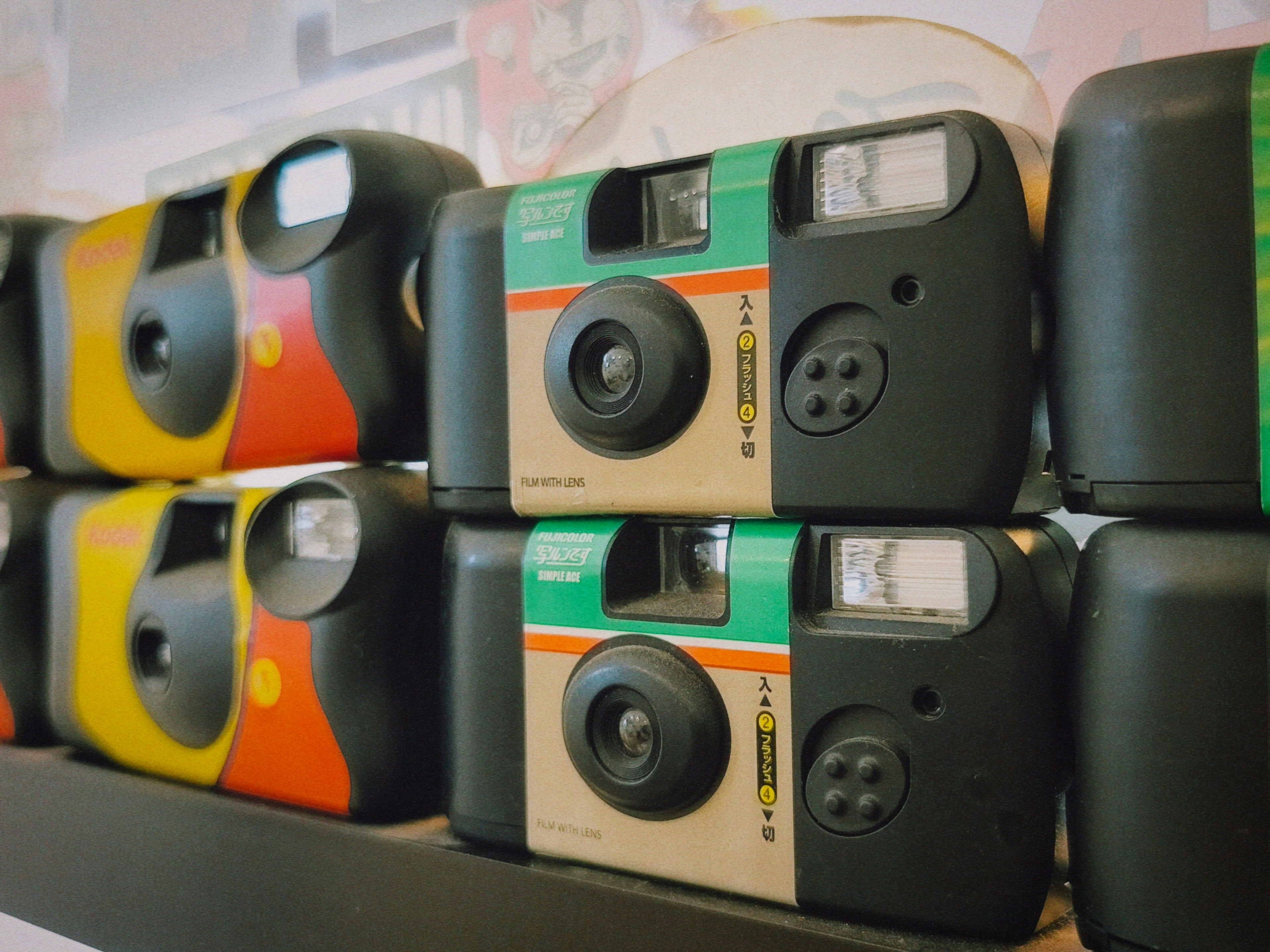 Stack of colorful disposable cameras on a shelf