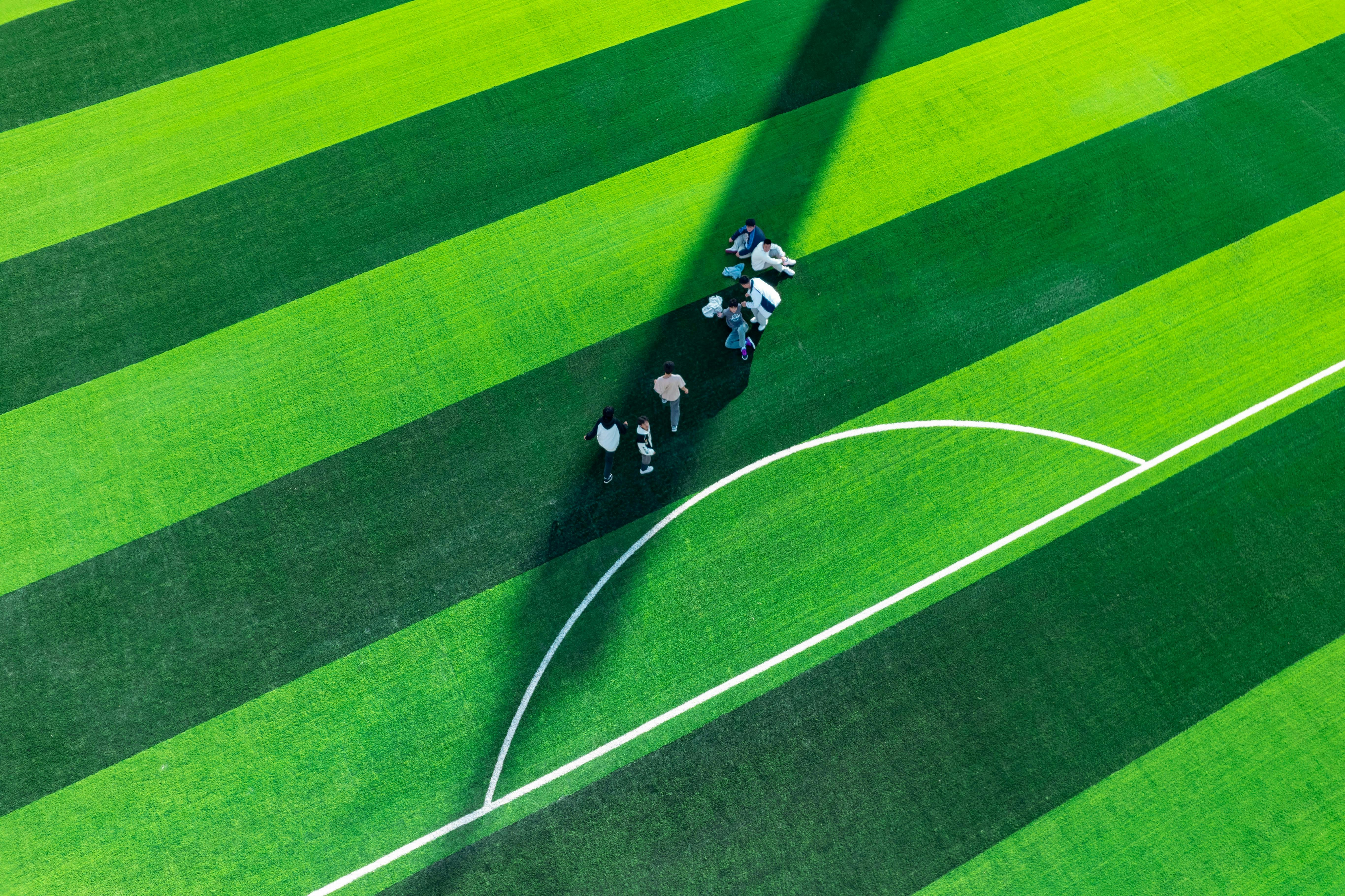 Vista aérea de un partido de fútbol con los equipos ordenados en mitad de cancha