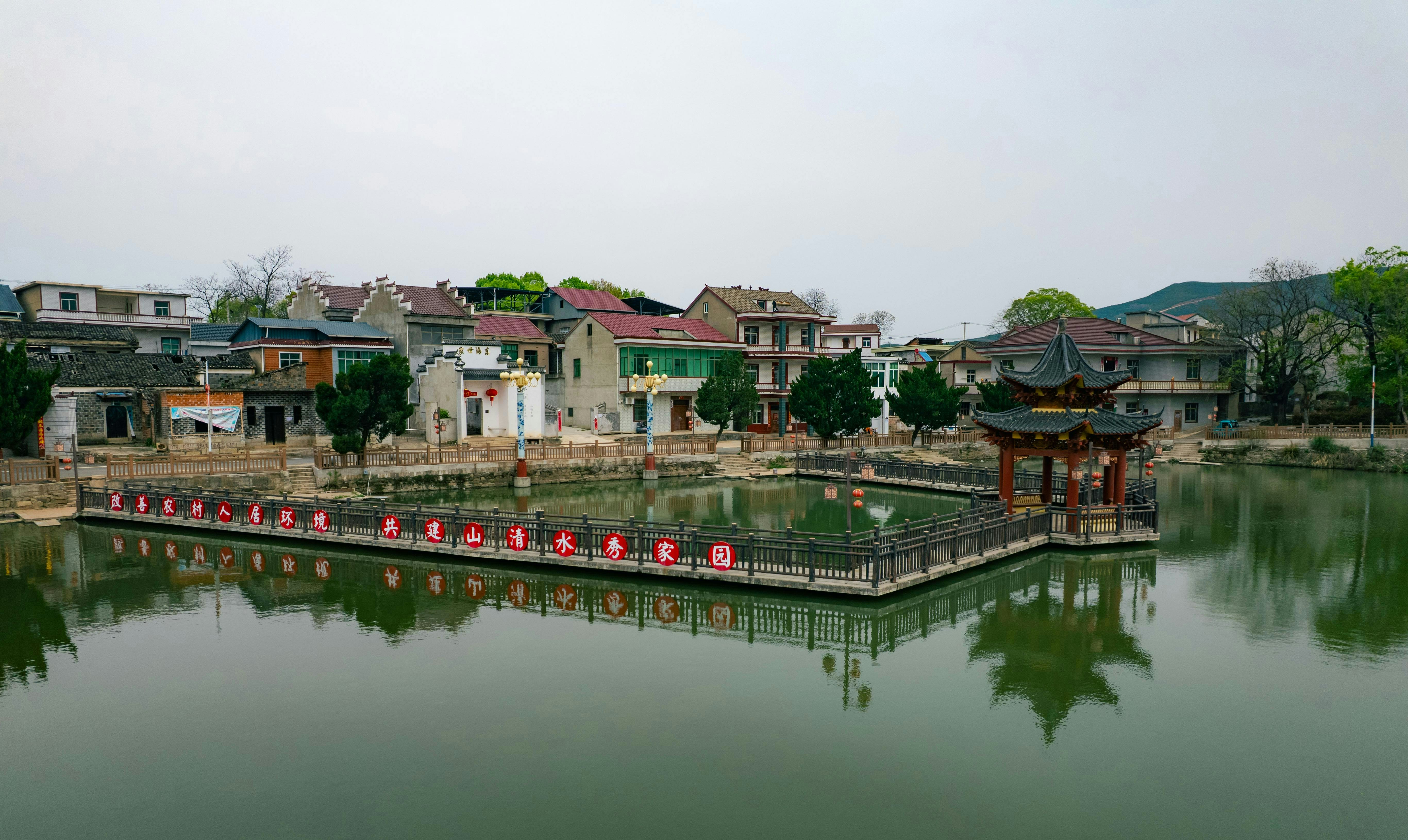 Traditional chinese village with a central pond and pavilion