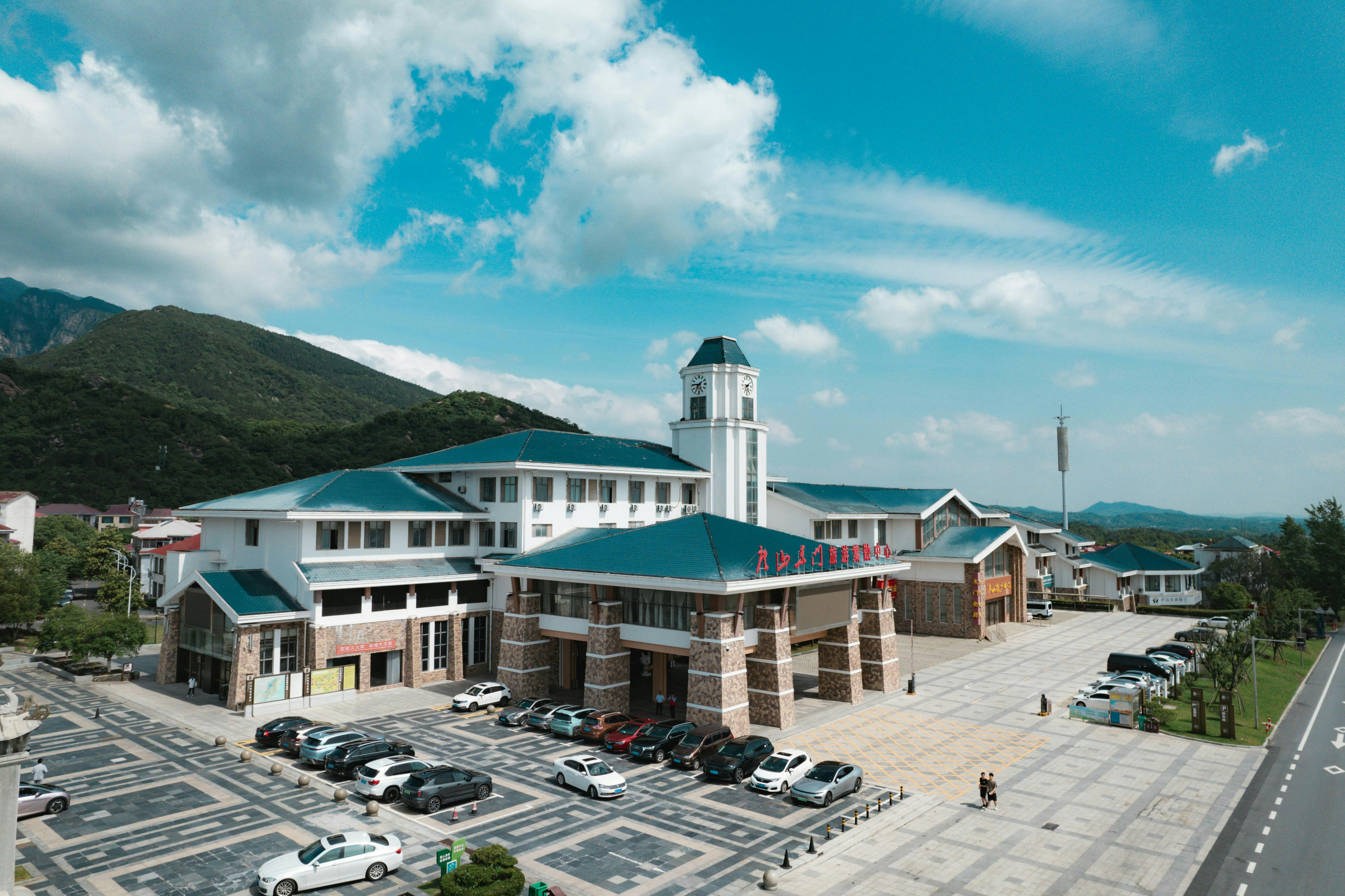 Modern building with cars parked outside under blue sky.