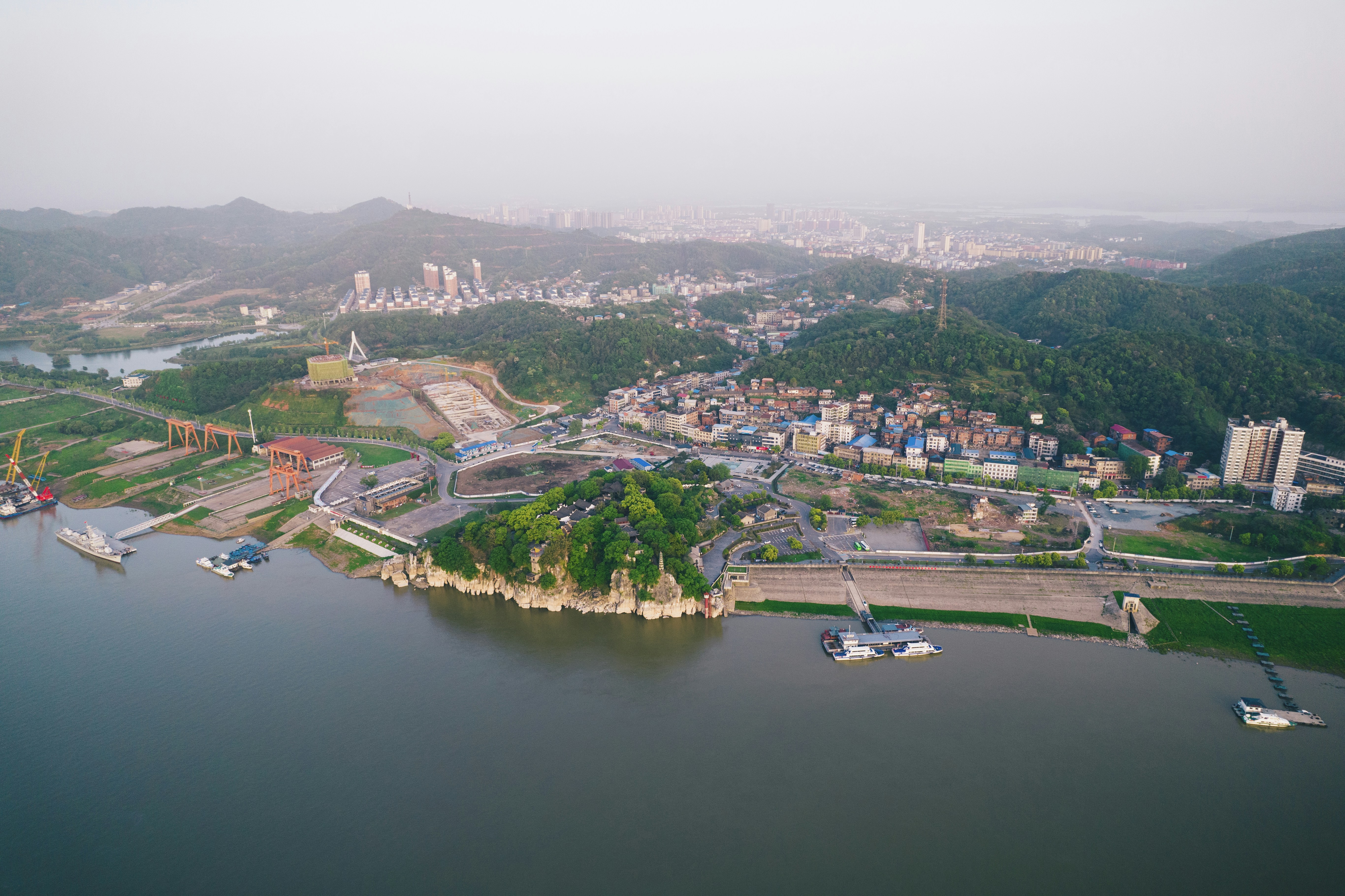 Aerial view of a coastal industrial city with mountains