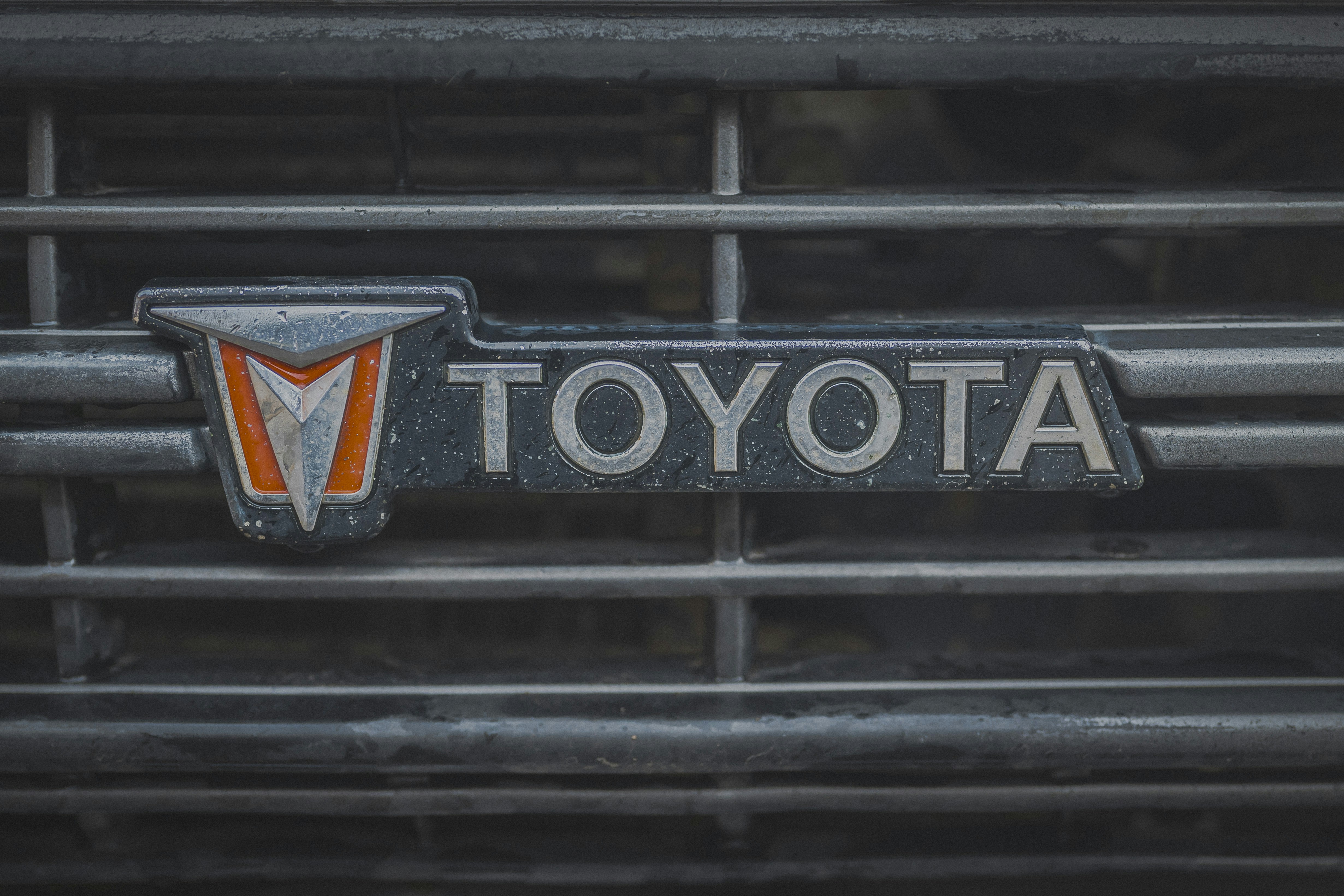 Close-up of a vintage toyota car emblem on a grille.