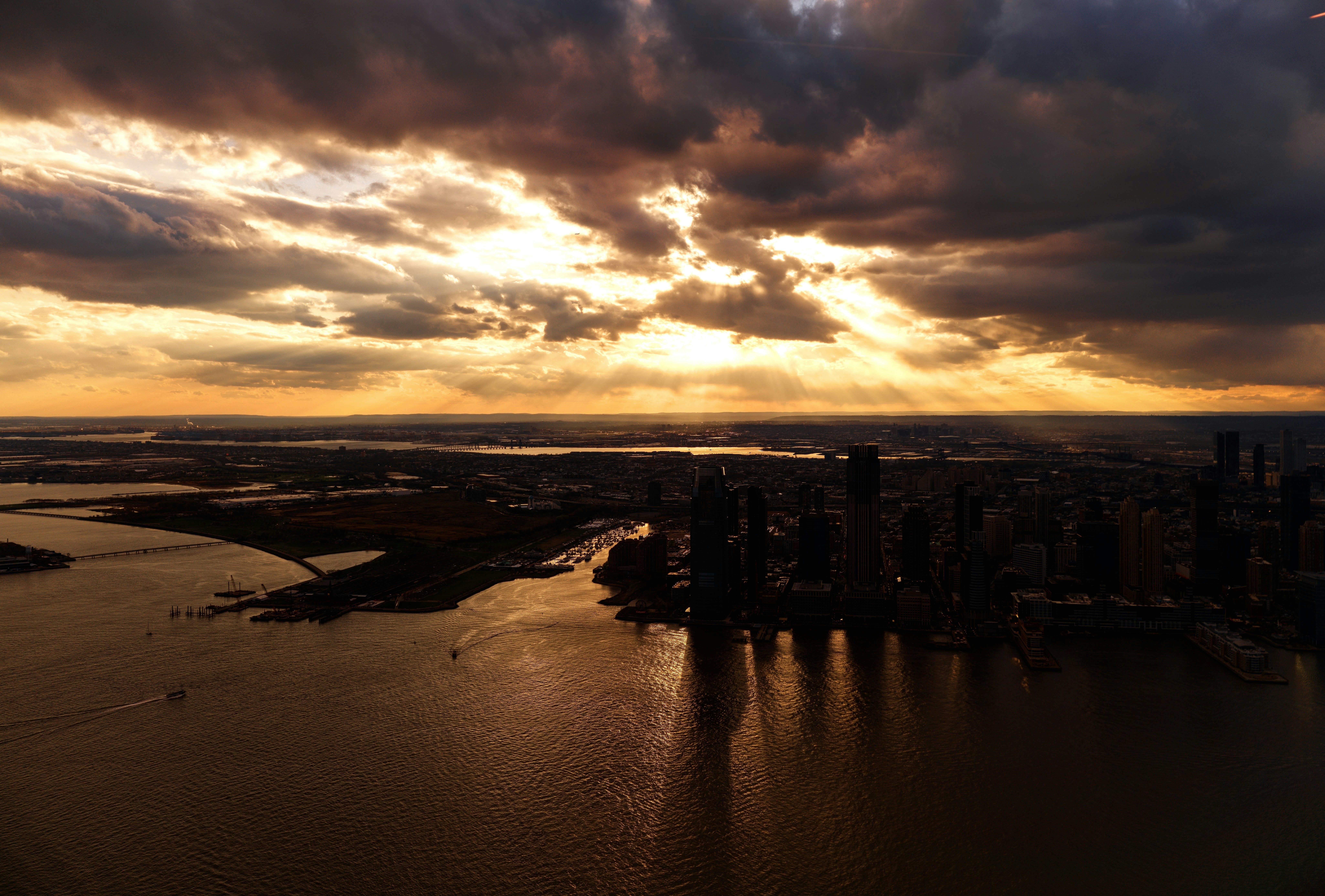 Puesta de sol dramática sobre el horizonte de una ciudad y el agua.