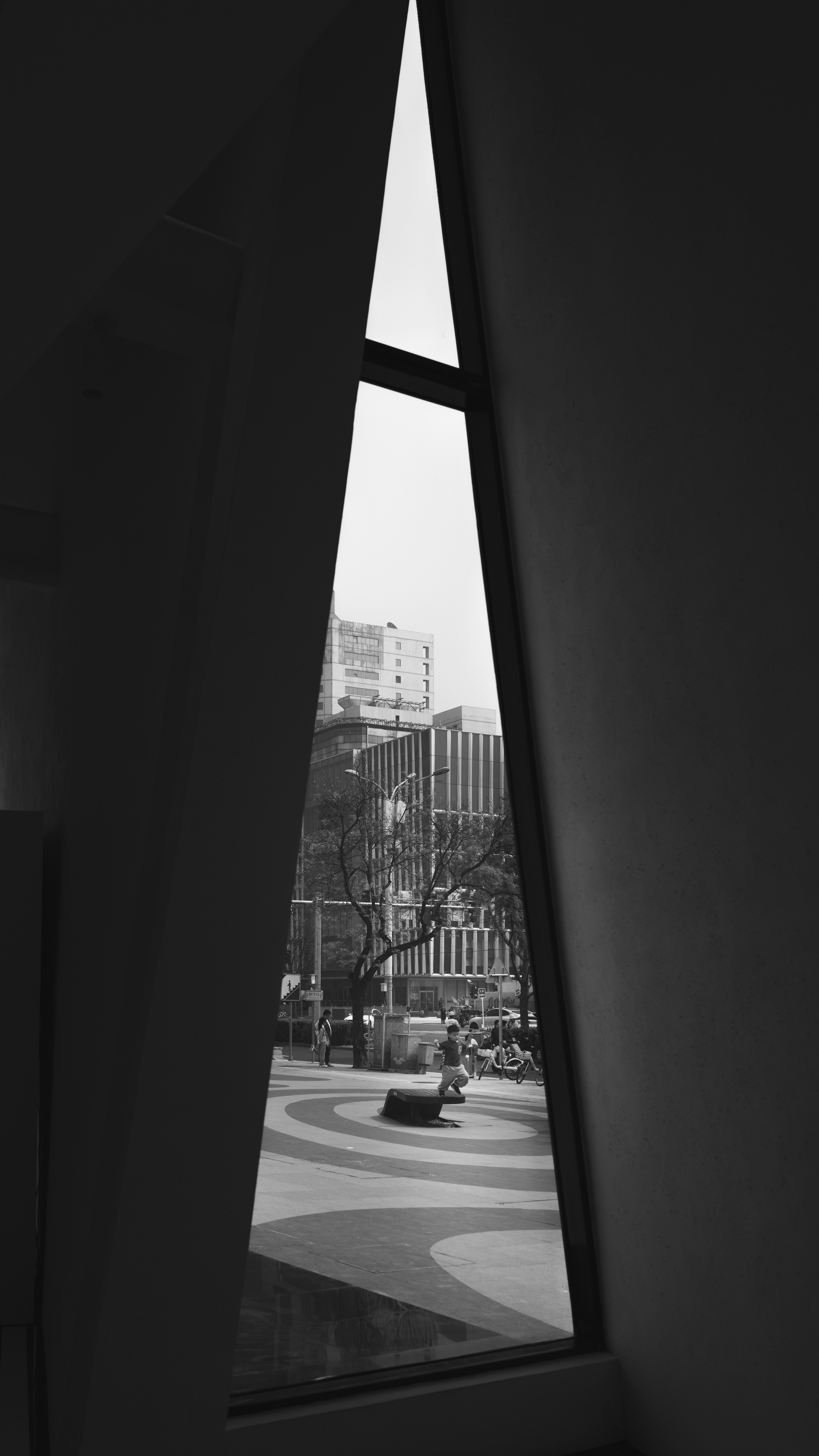 View of city buildings through a triangular window.