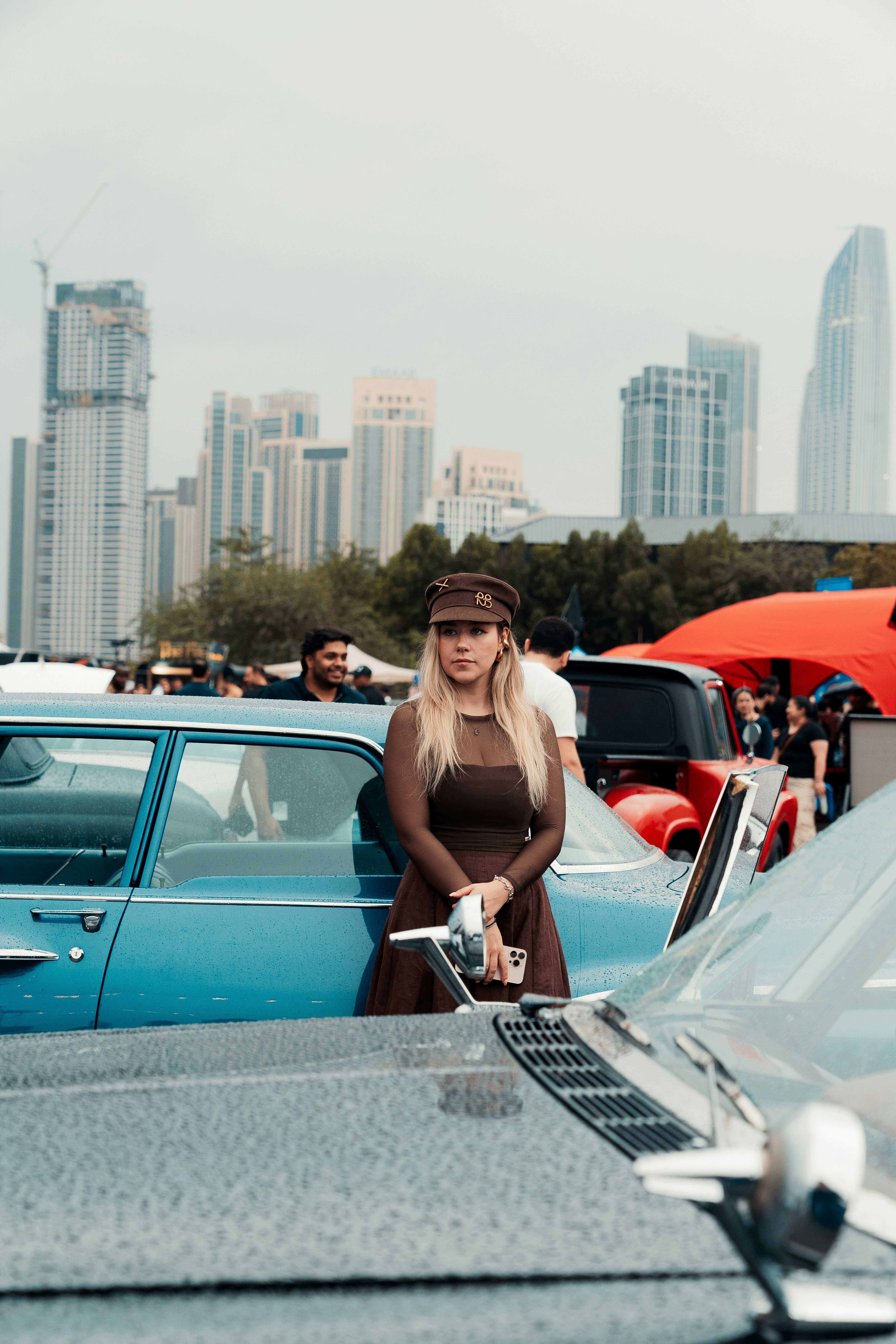 Femme en robe vintage lors d’un salon automobile