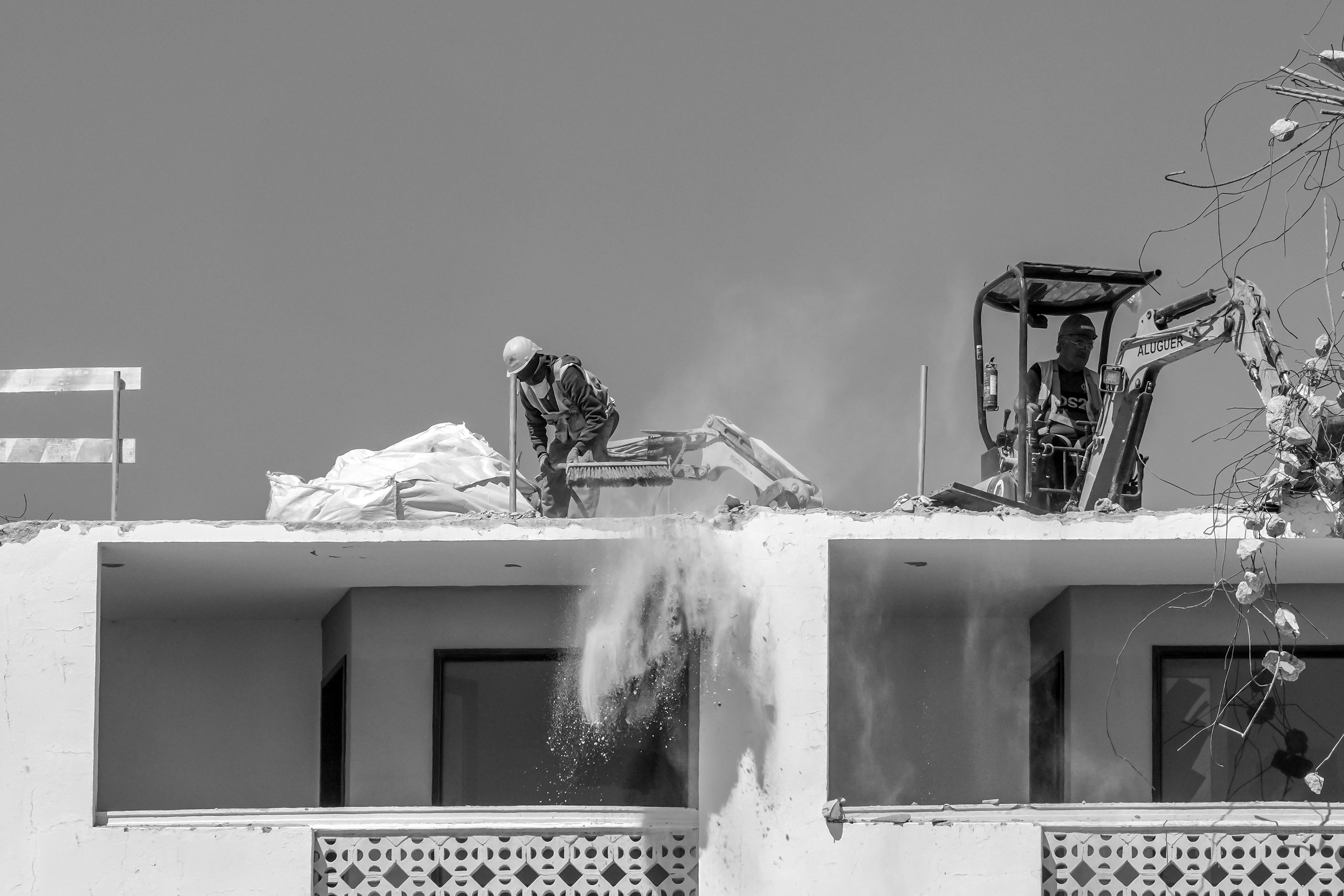 Workers demolishing a building with heavy machinery