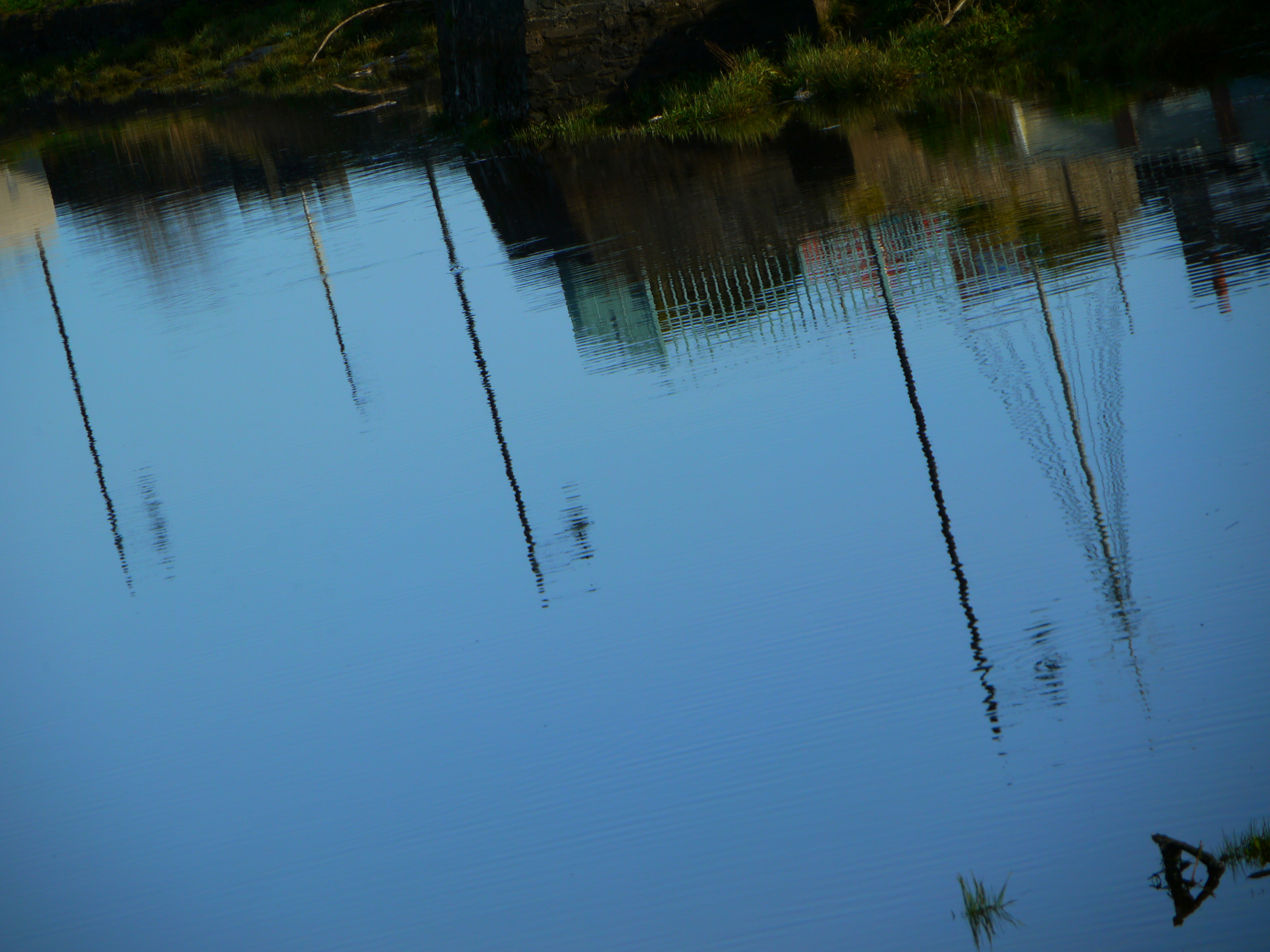 Reflection of structures in calm blue water