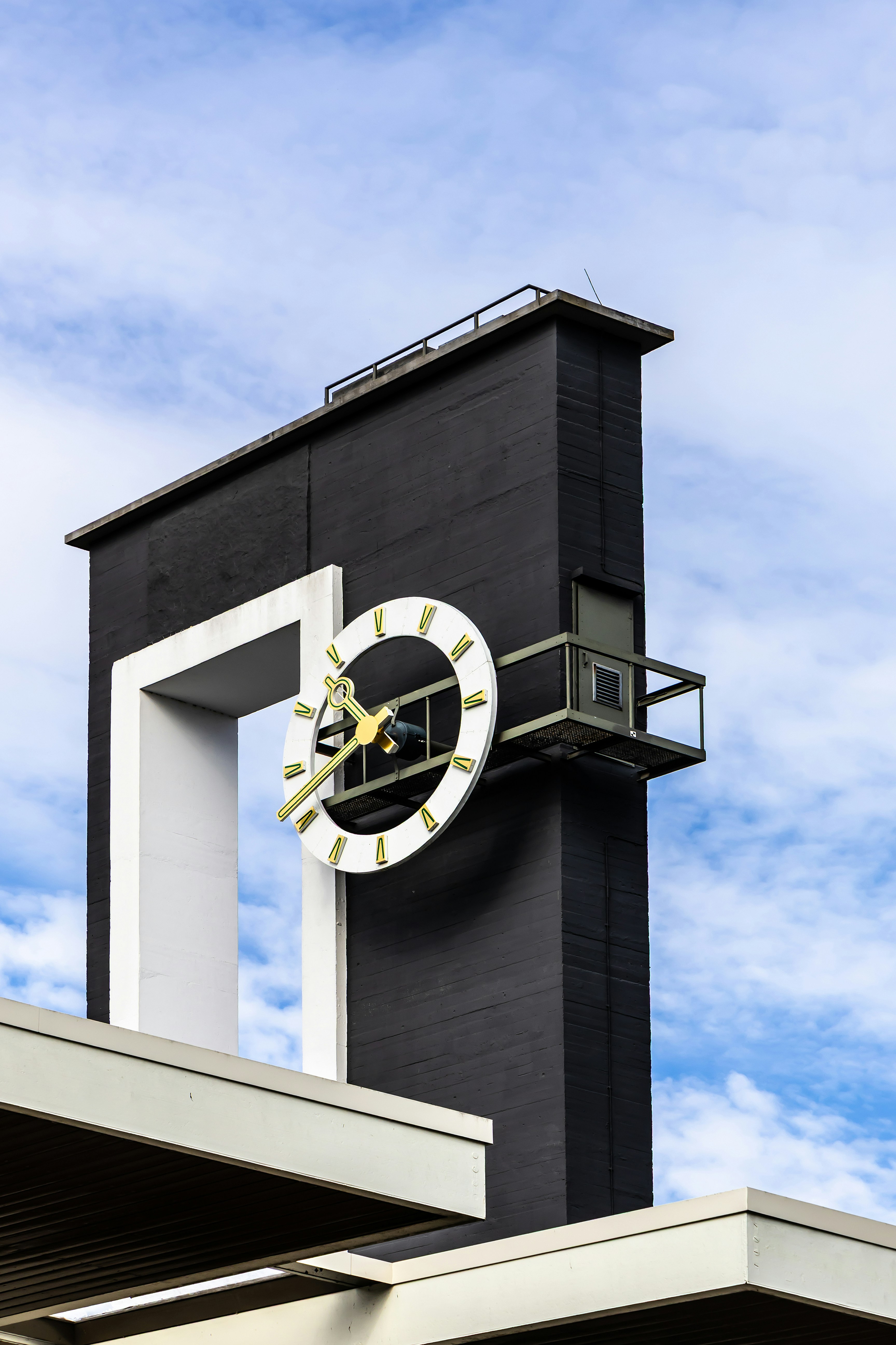 Modern clock tower against a cloudy sky