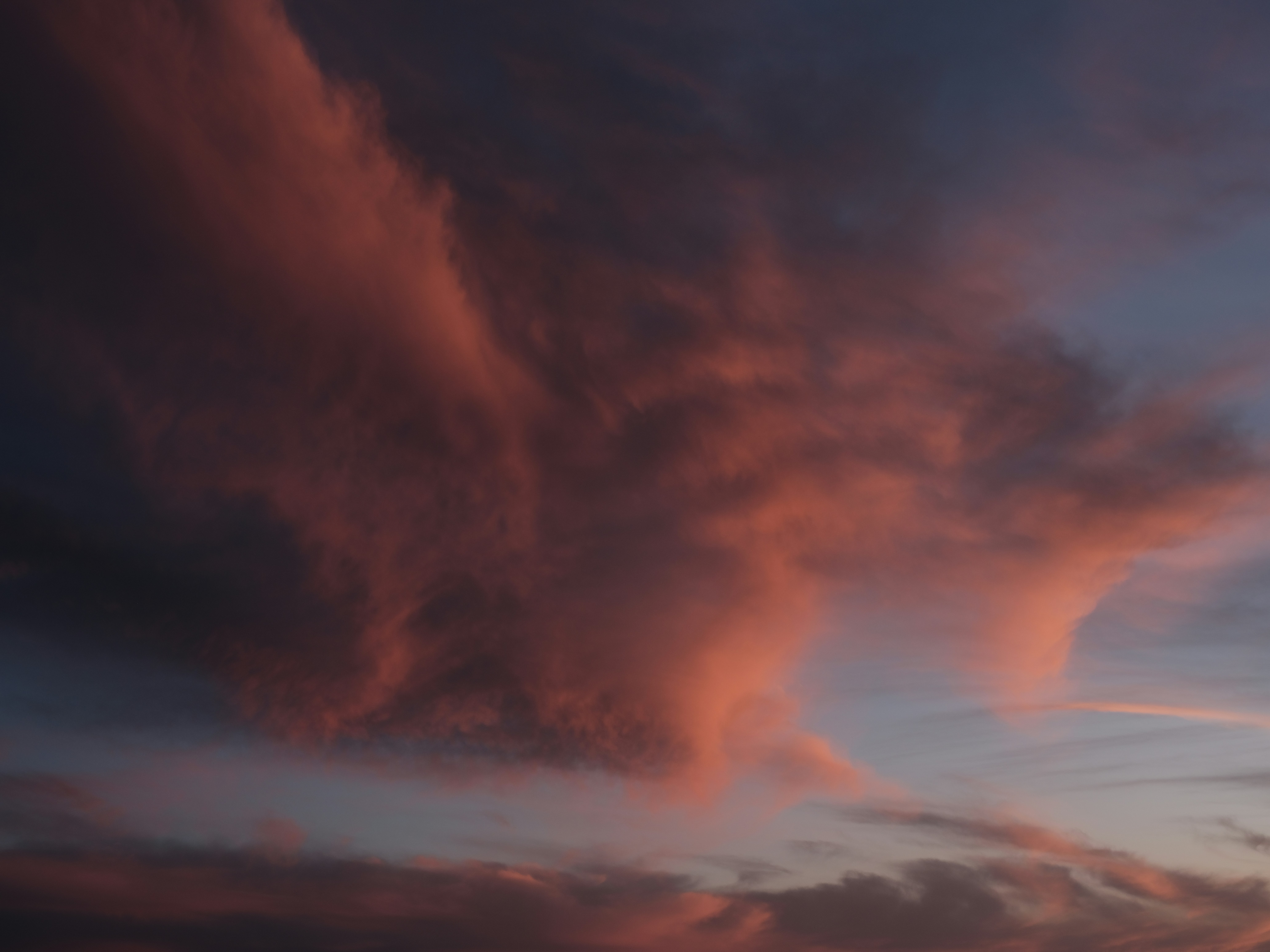 Dramatic pink clouds against a twilight sky