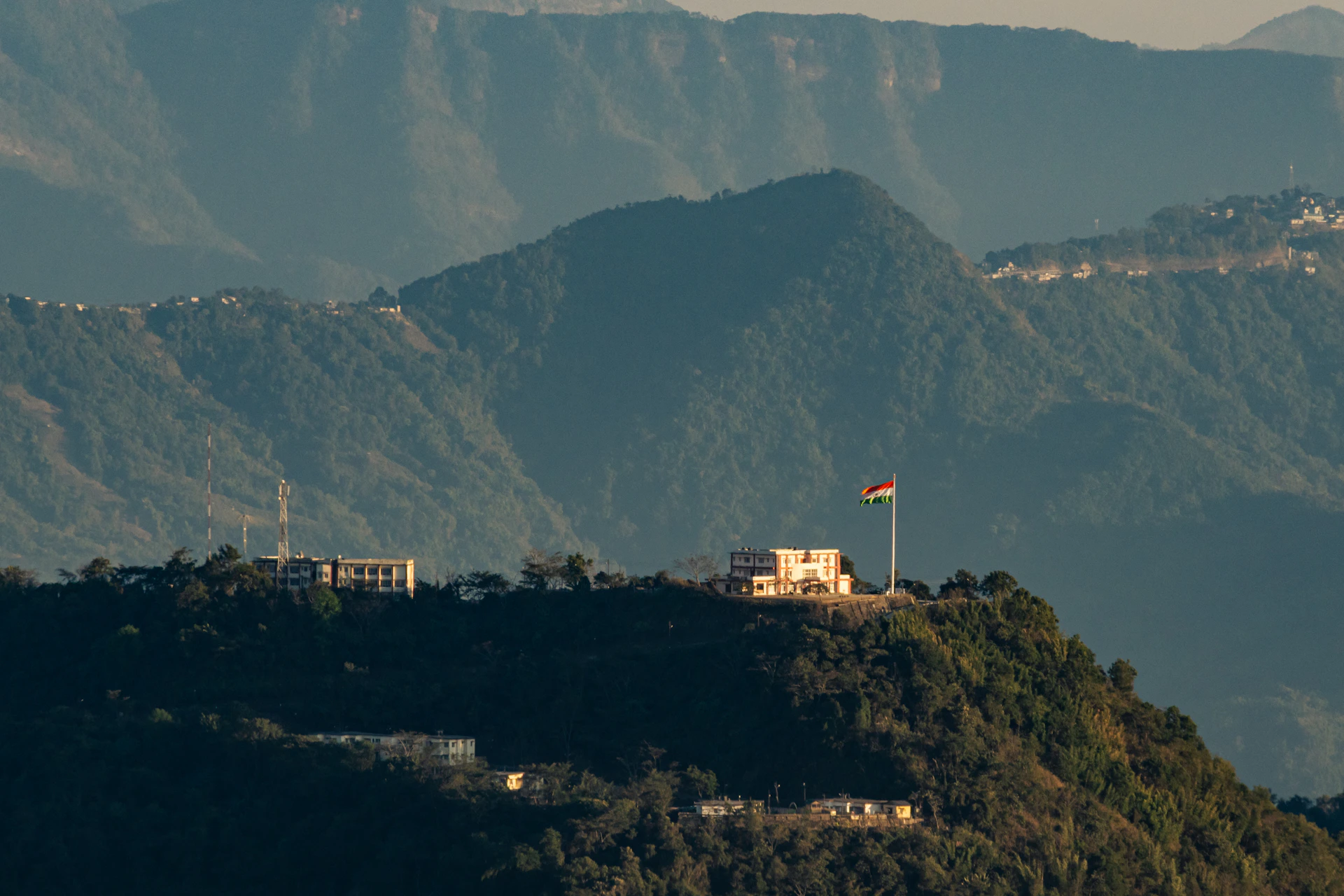 Buildings on a mountaintop with a flag