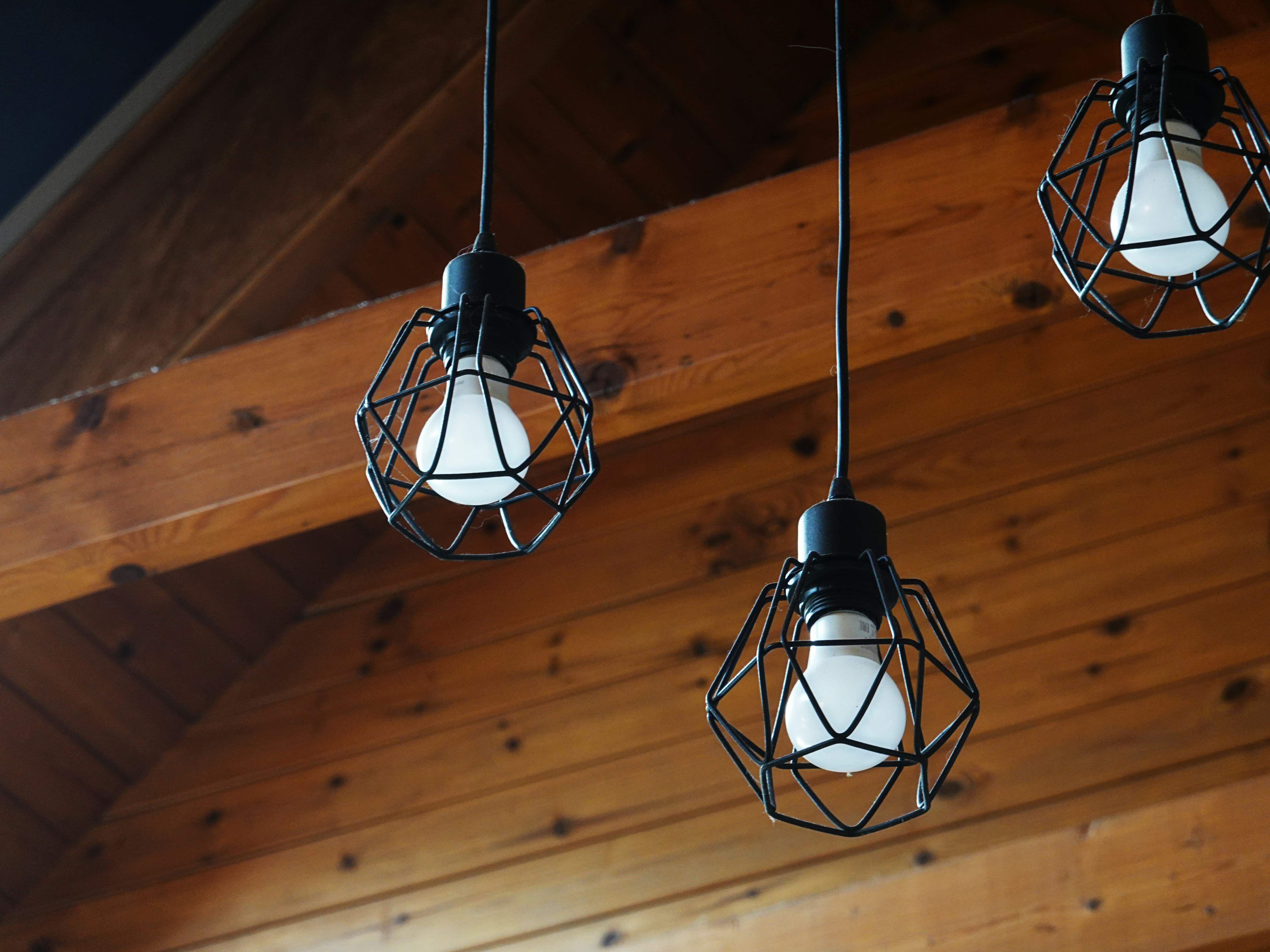 Three industrial-style pendant lights hanging indoors.