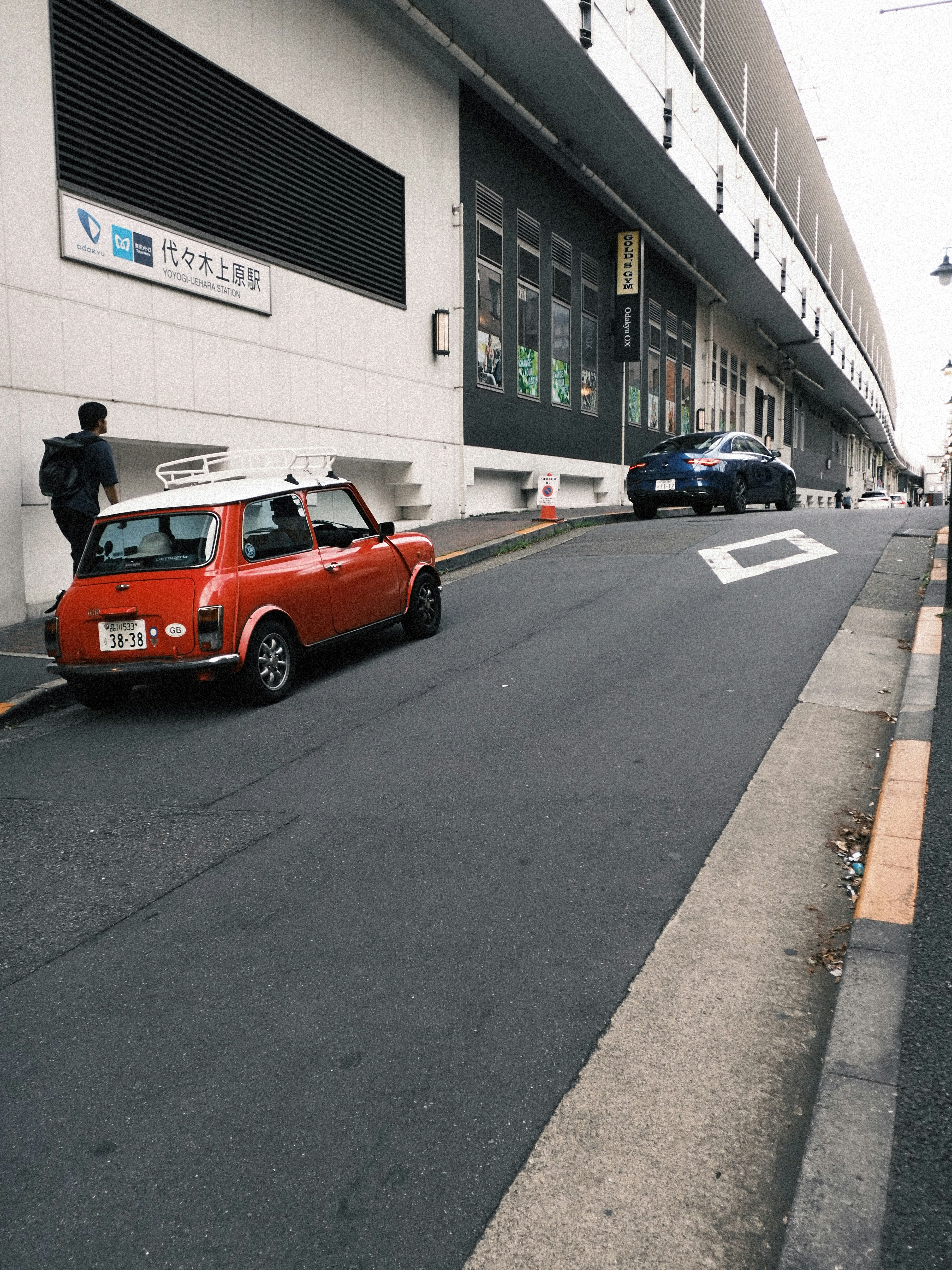 Mini Cooper vermelho estacionado numa rua da cidade.