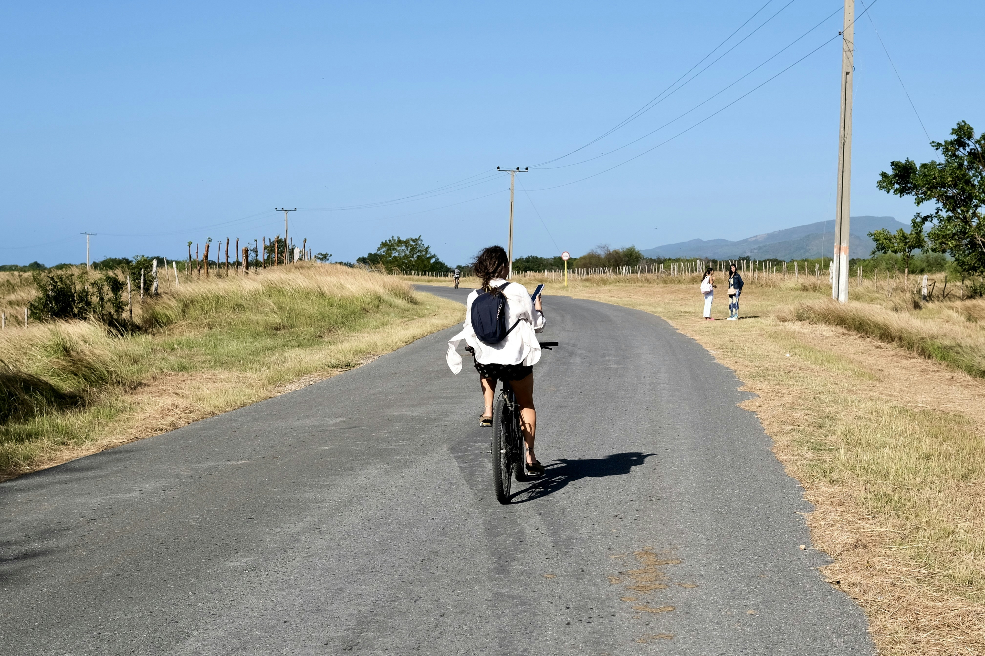 Person riding a bicycle on a rural road.
