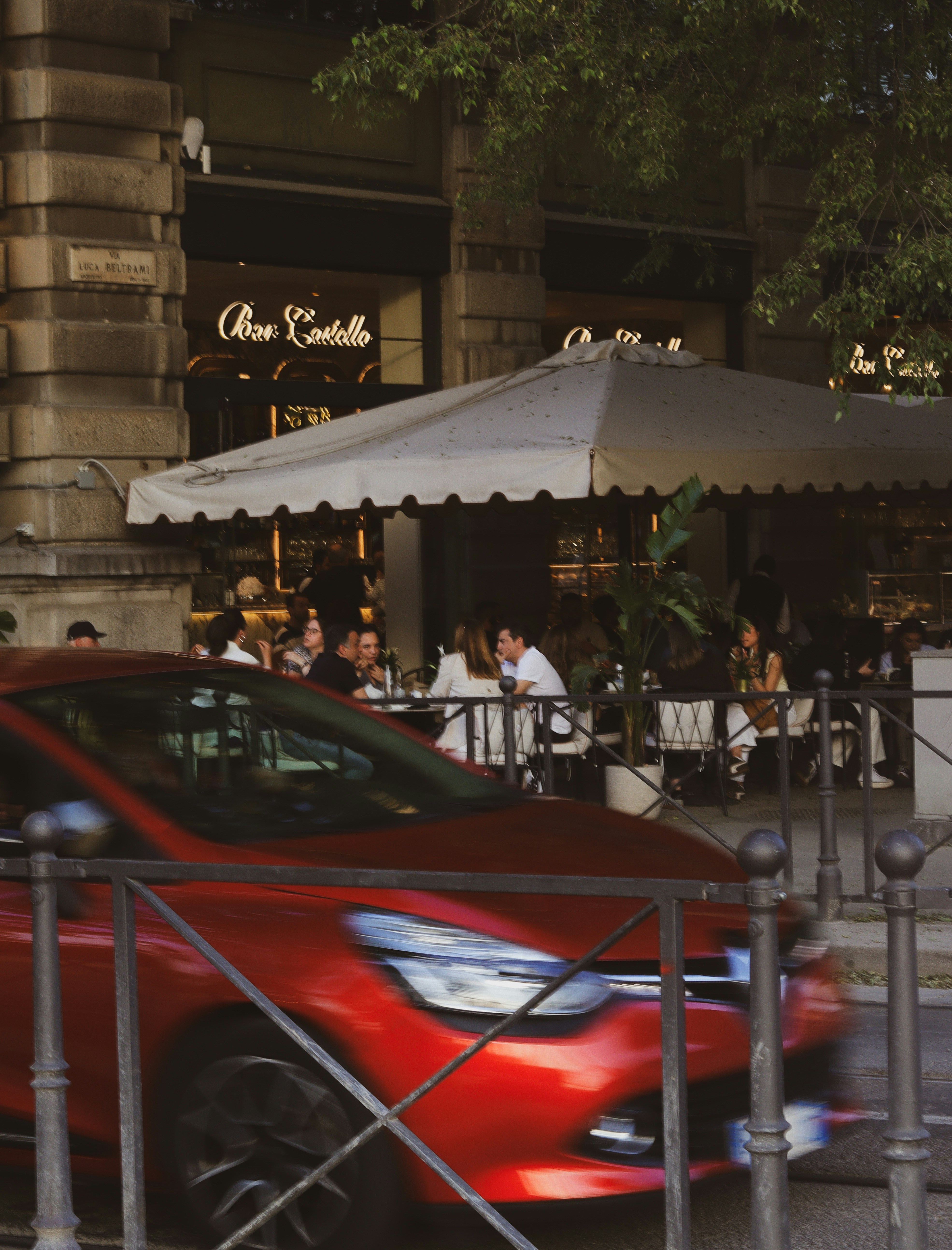 As pessoas jantam ao ar livre em cafés com carros passando