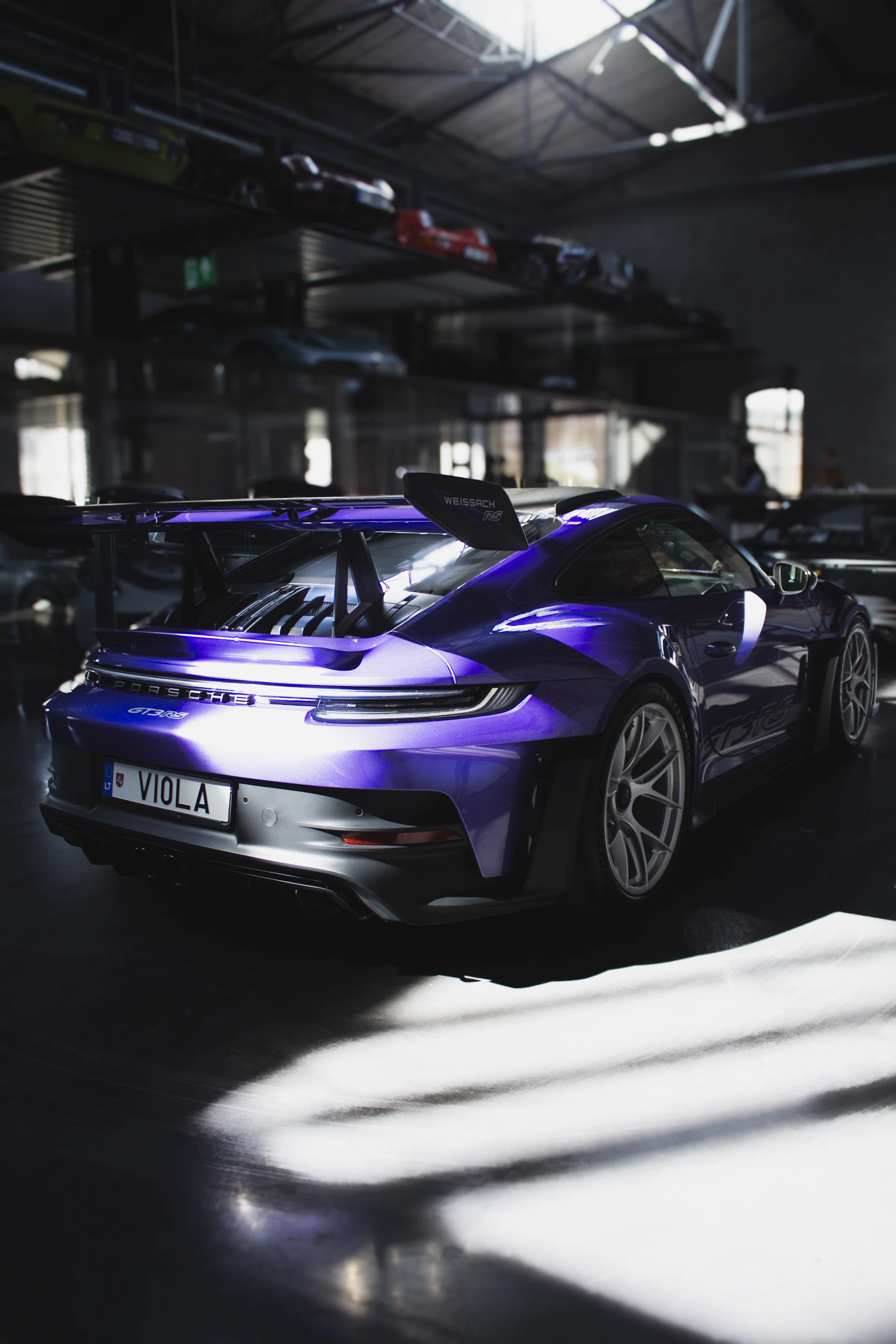 Purple sports car parked in a dimly lit garage