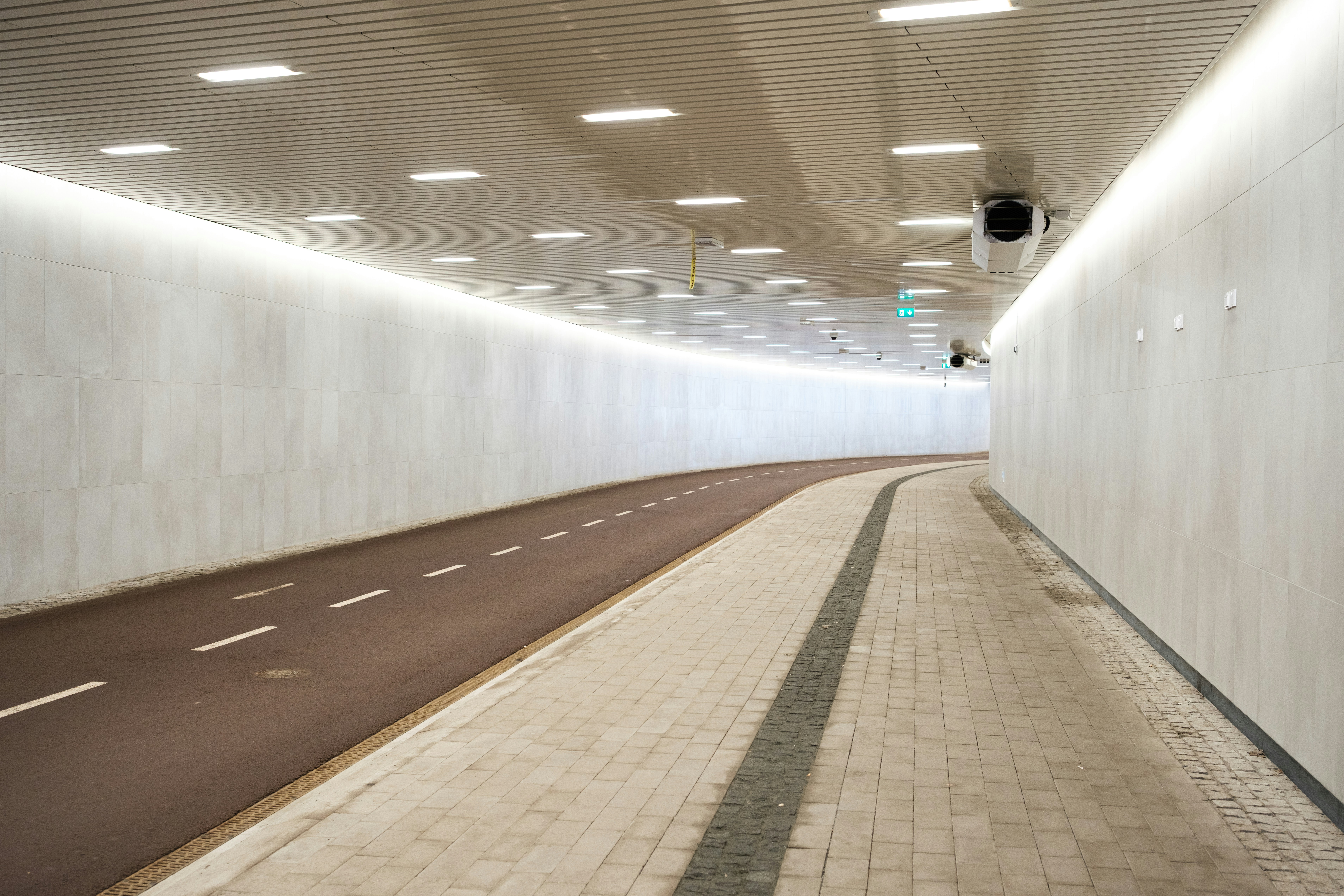 Túnel iluminado moderno con caminos separados para ciclismo y senderismo