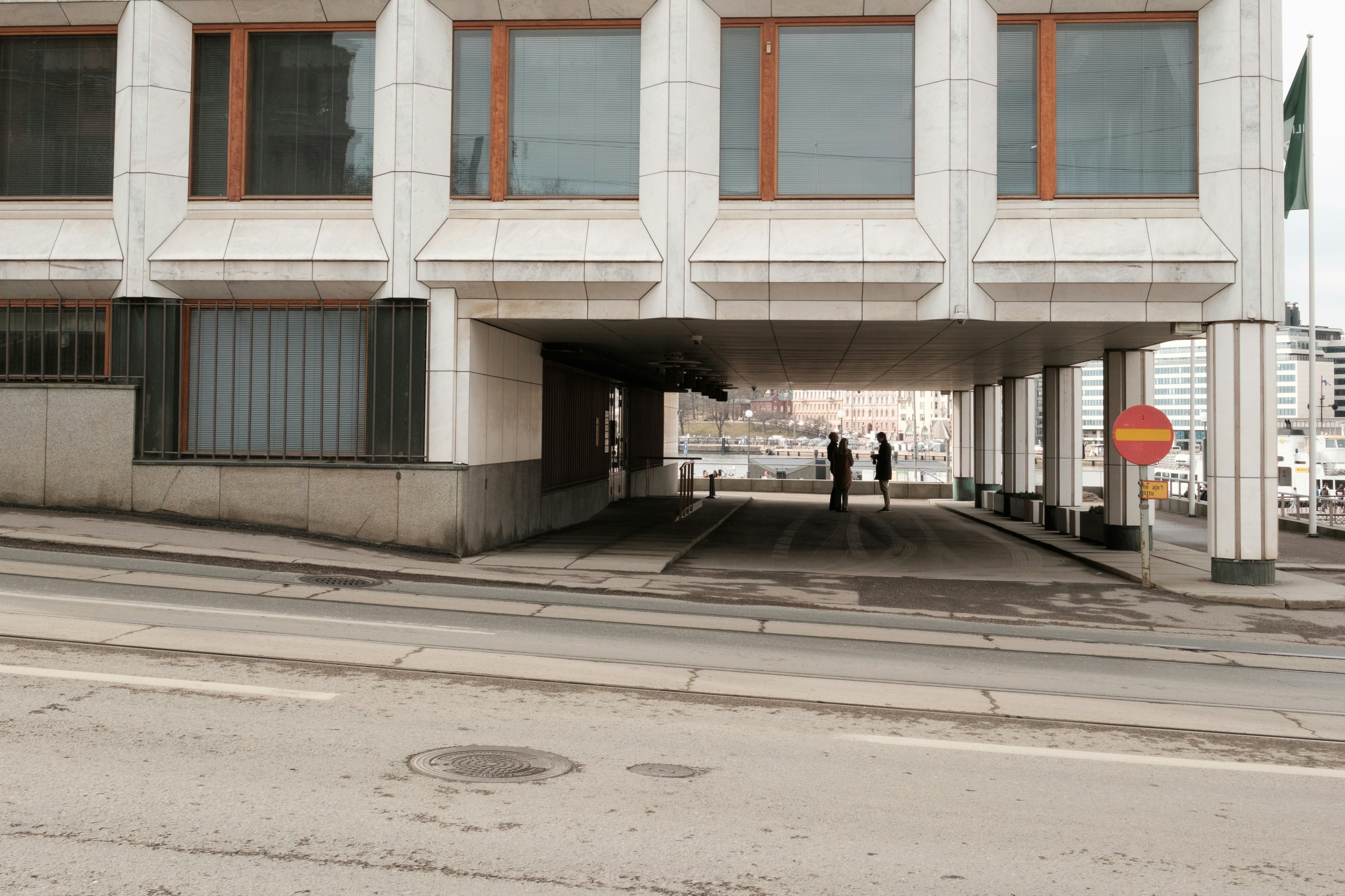 Dos personas están bajo un saliente moderno de edificio.