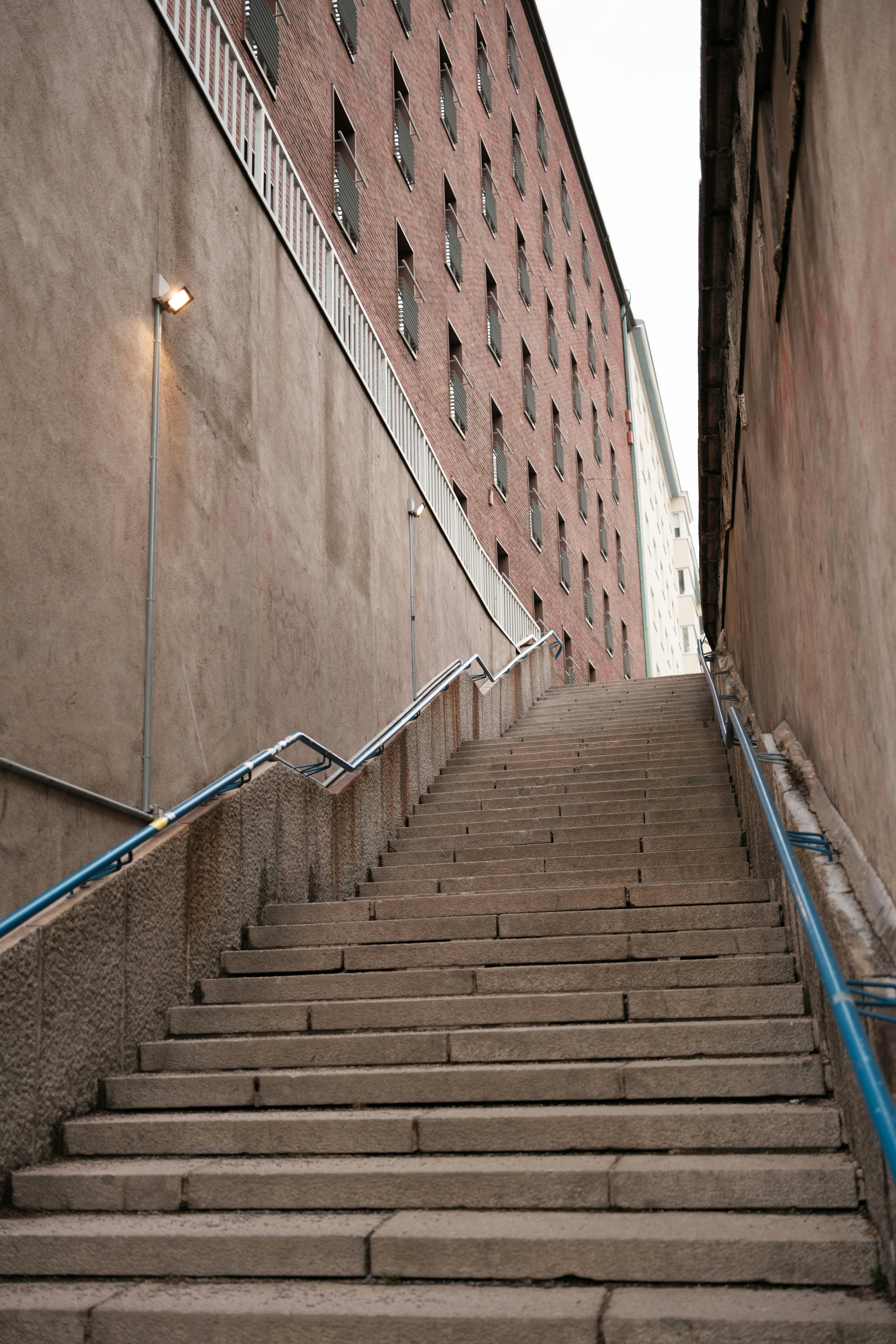 Escalera de piedra que sube entre edificios de ladrillo