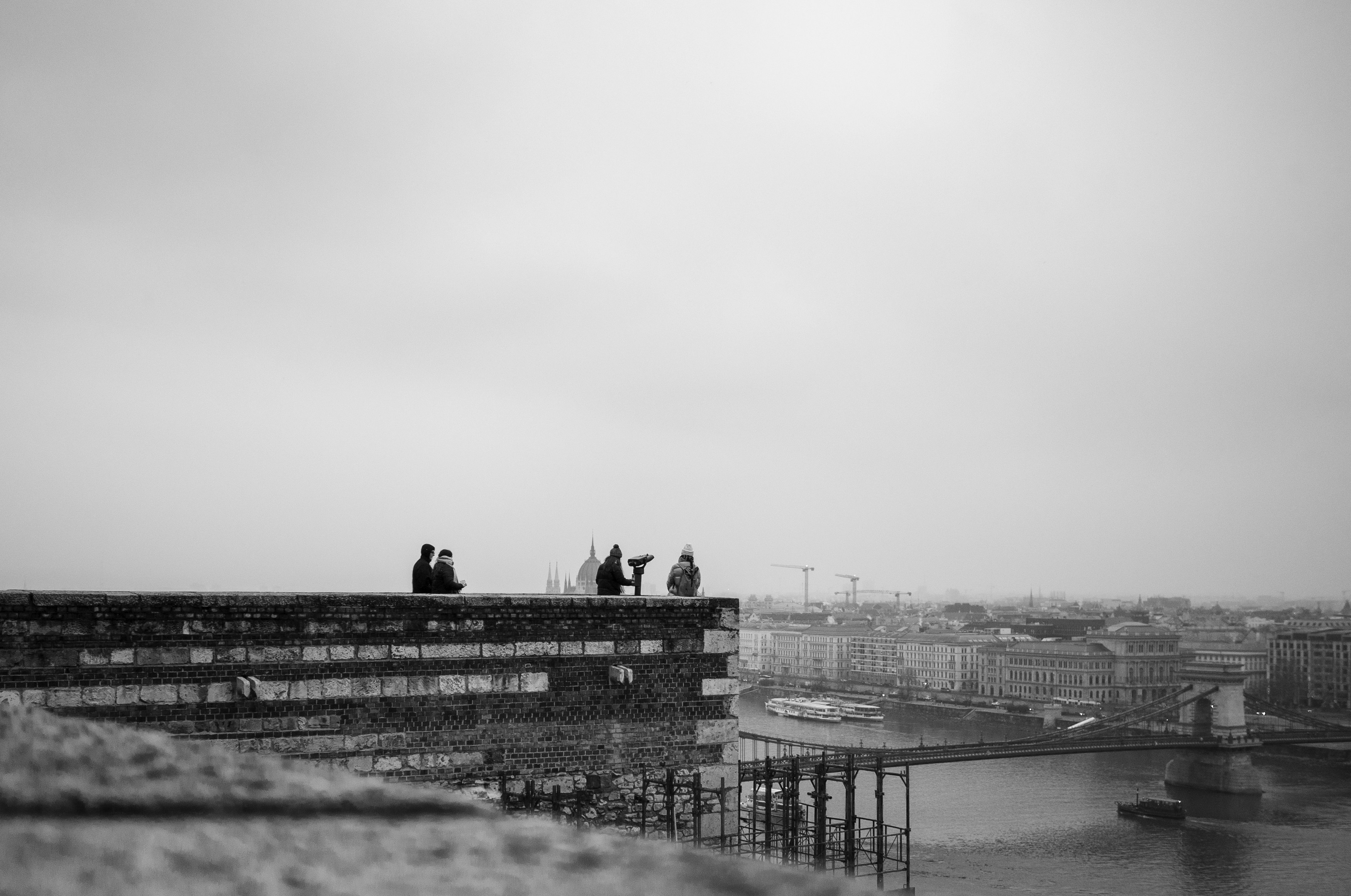 People silhouetted on a rooftop overlooking a city