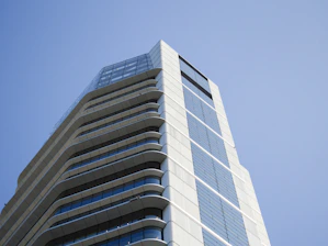 Modern skyscraper with glass facade against clear blue sky