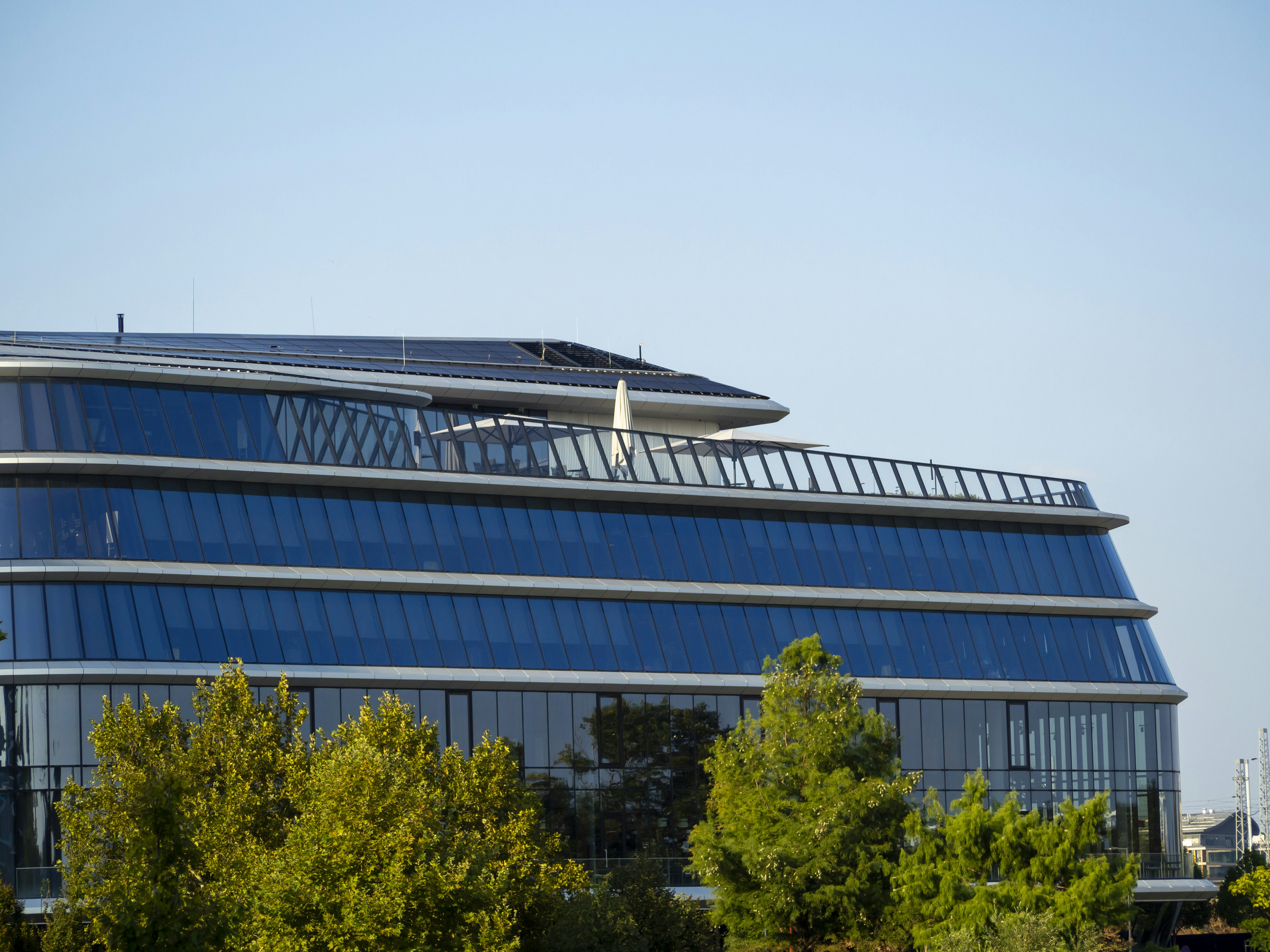 modern tech company headquarters office building glass facade - Modern glass building with solar panels on roof.