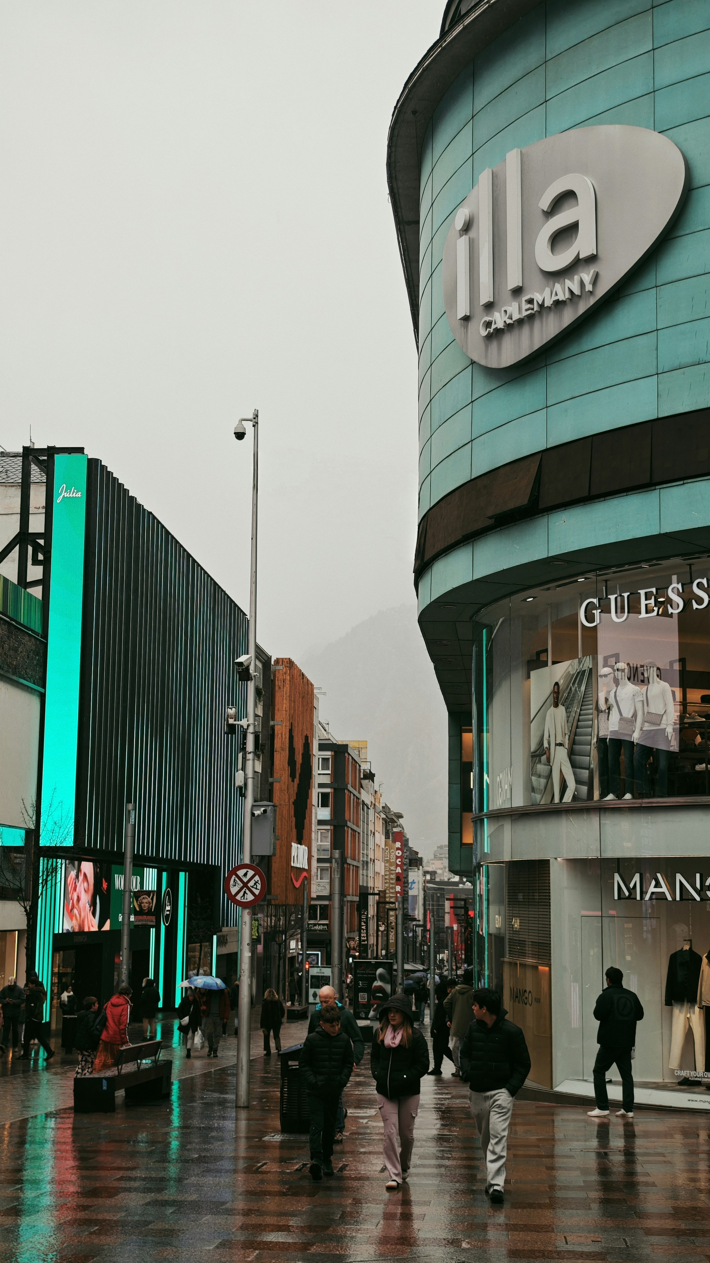 People walking on a wet street in a city