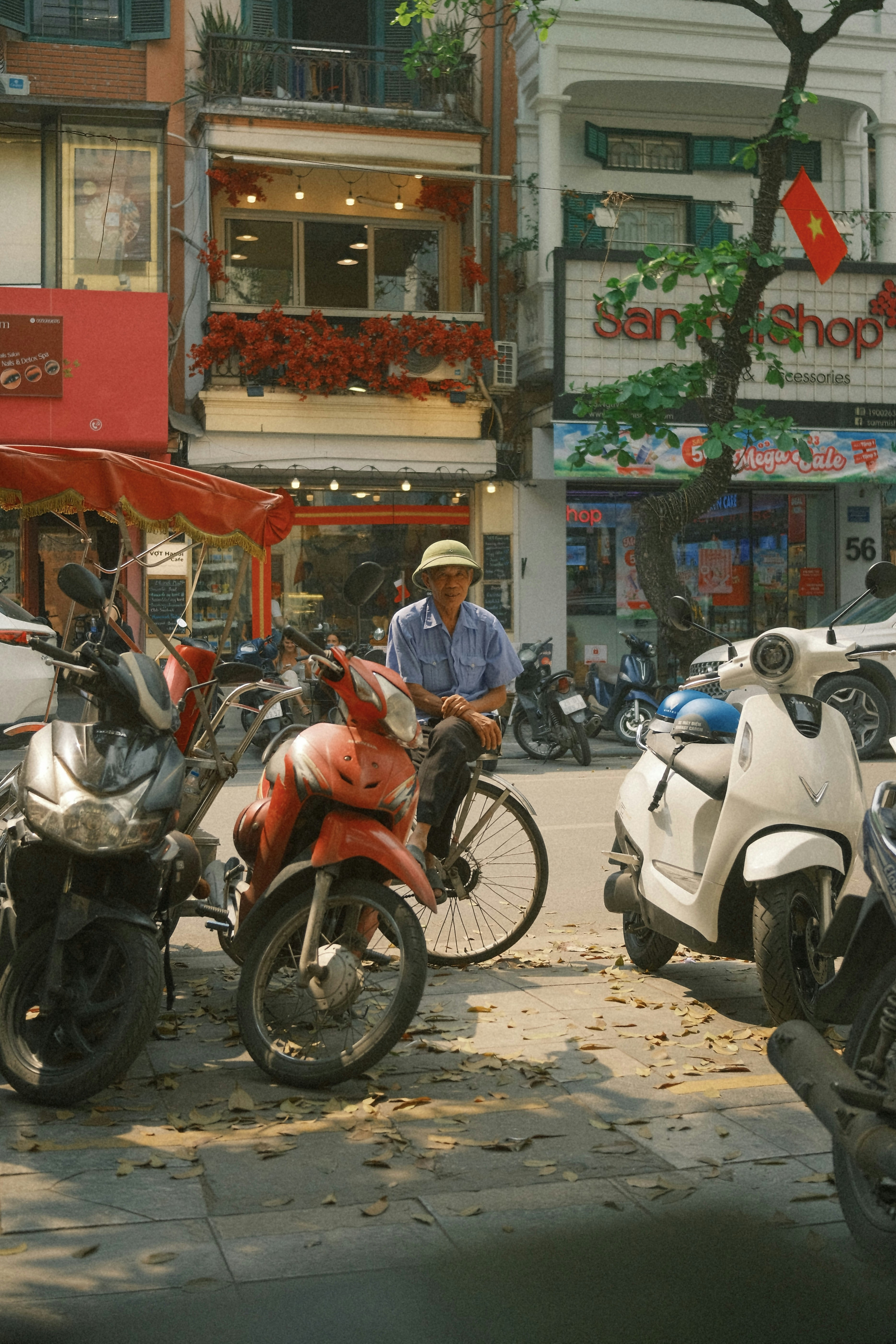 Uomo con cappello va in bicicletta per strada con le motociclette