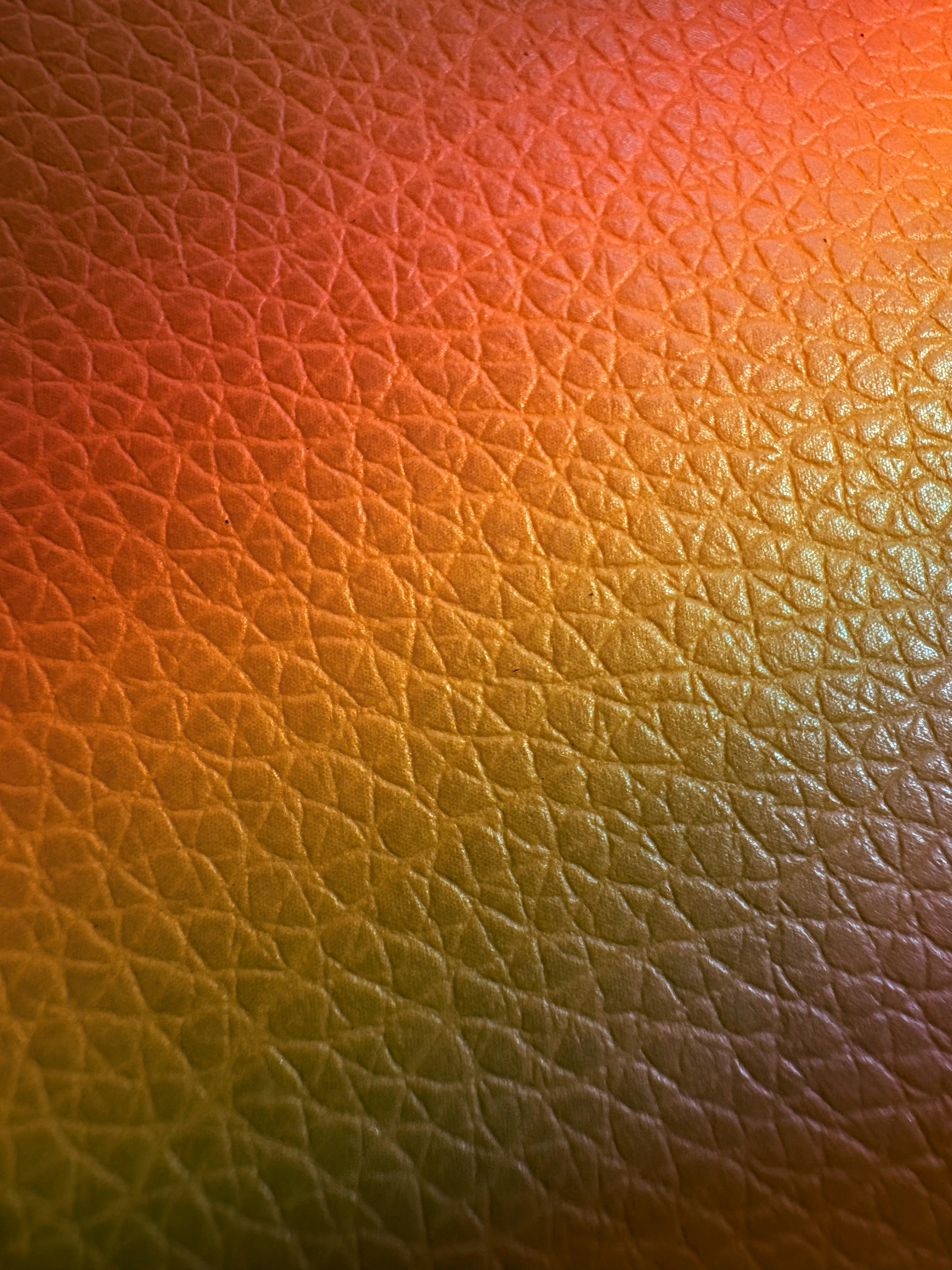 Close-up of textured leather with warm color gradient.