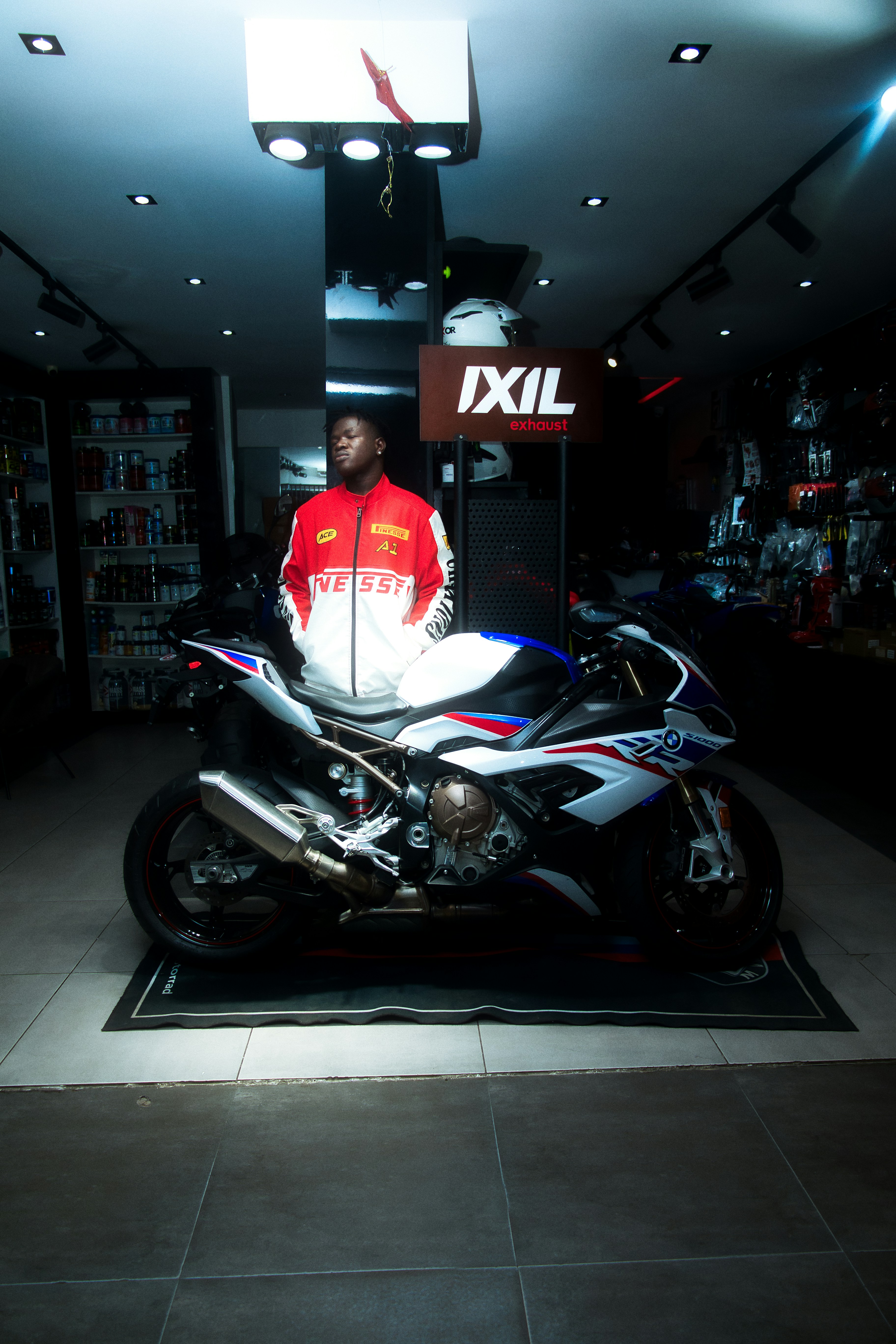Man standing next to a sport motorcycle indoors.