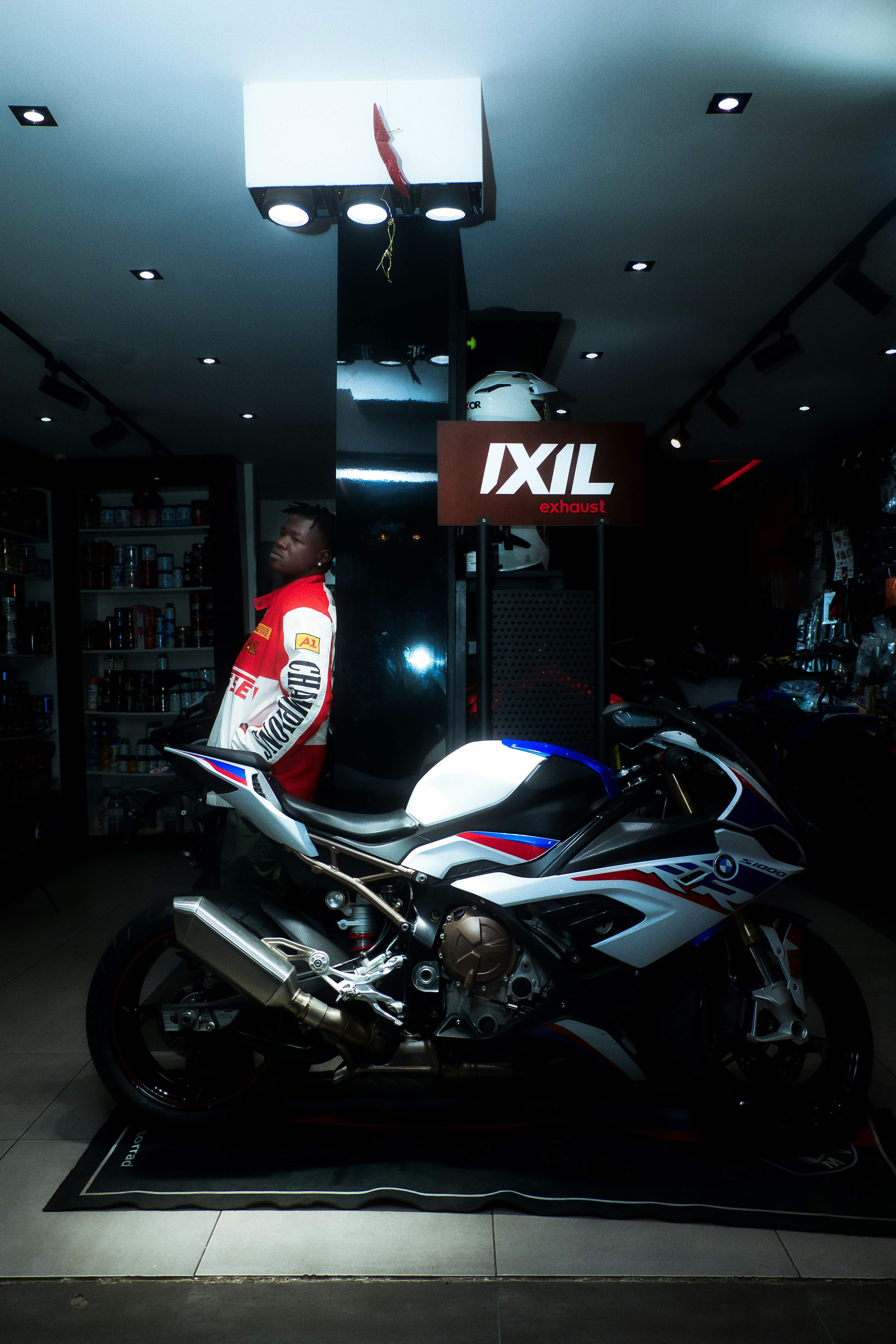 Man standing next to a sport motorcycle indoors.