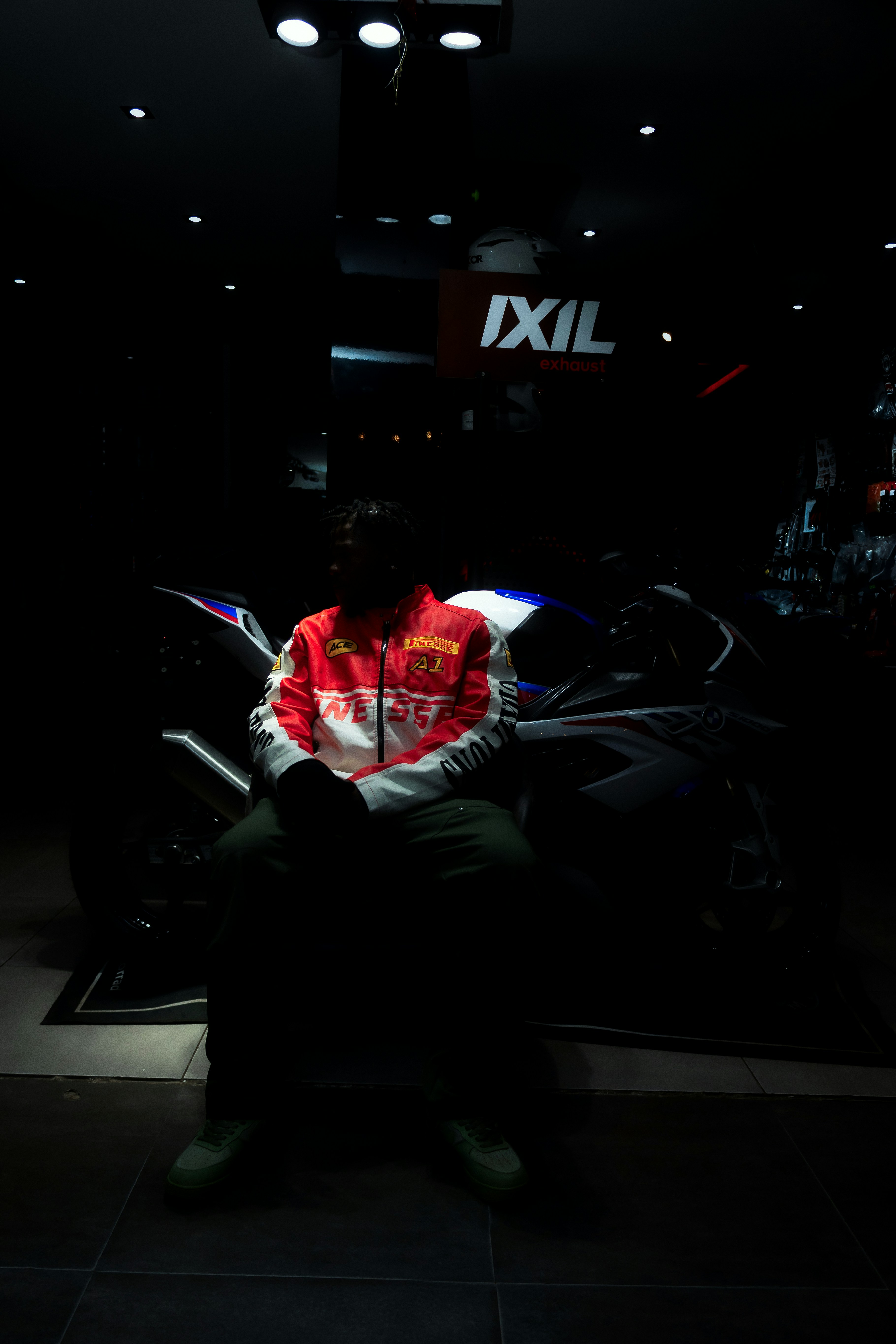 Man in racing jacket sits on a motorcycle