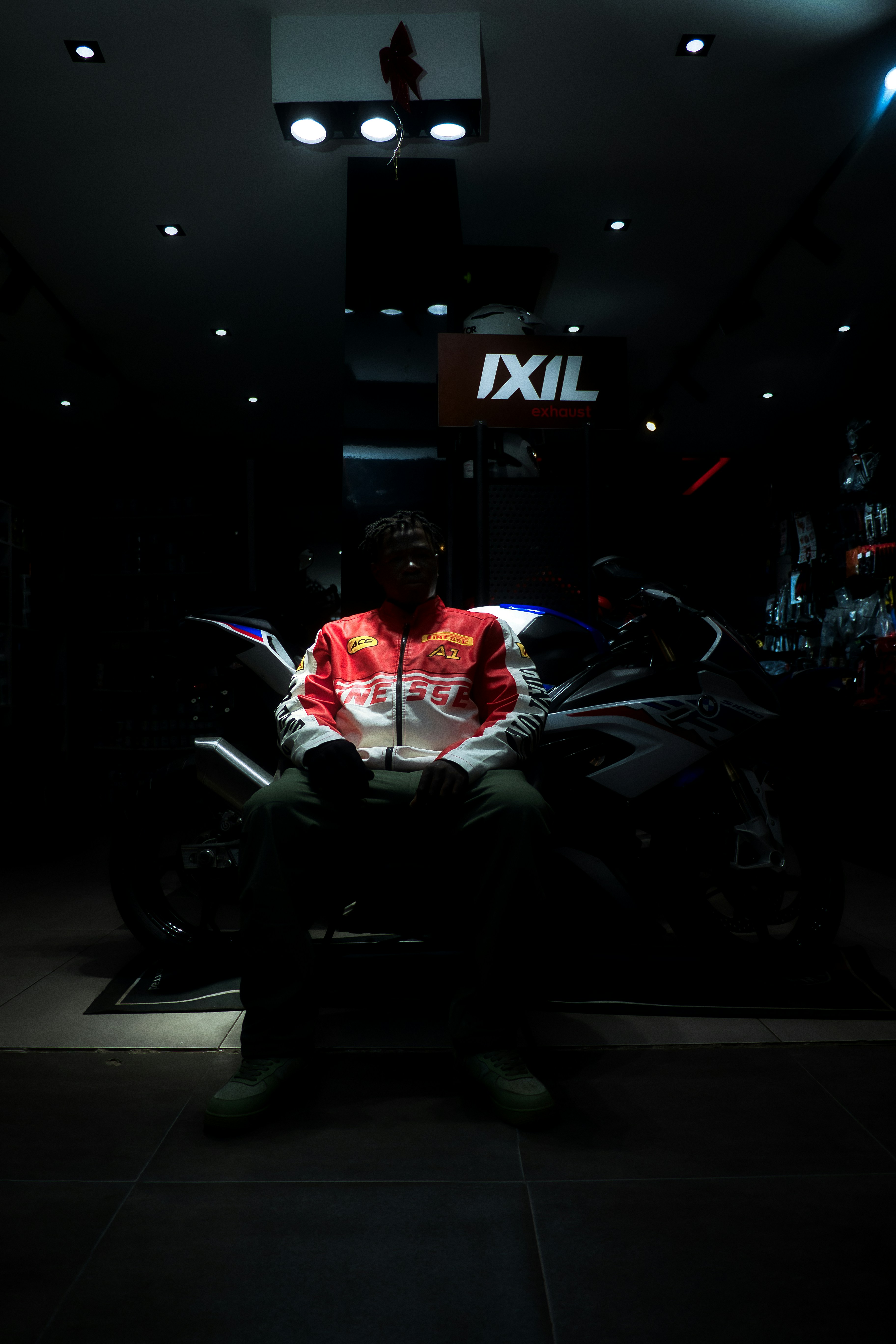 Man sitting on a motorcycle in a dark showroom