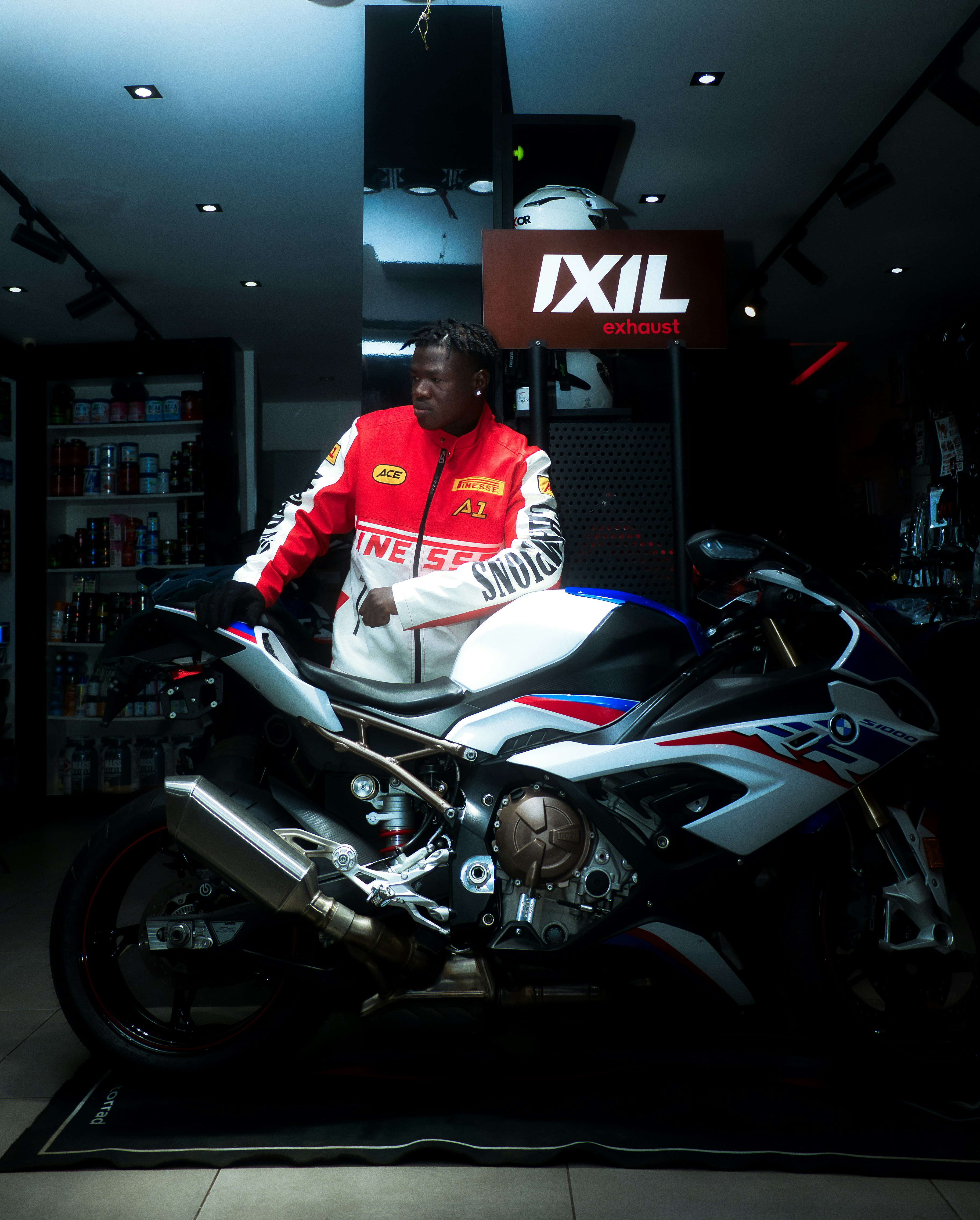 Man in racing jacket leaning on sport motorcycle