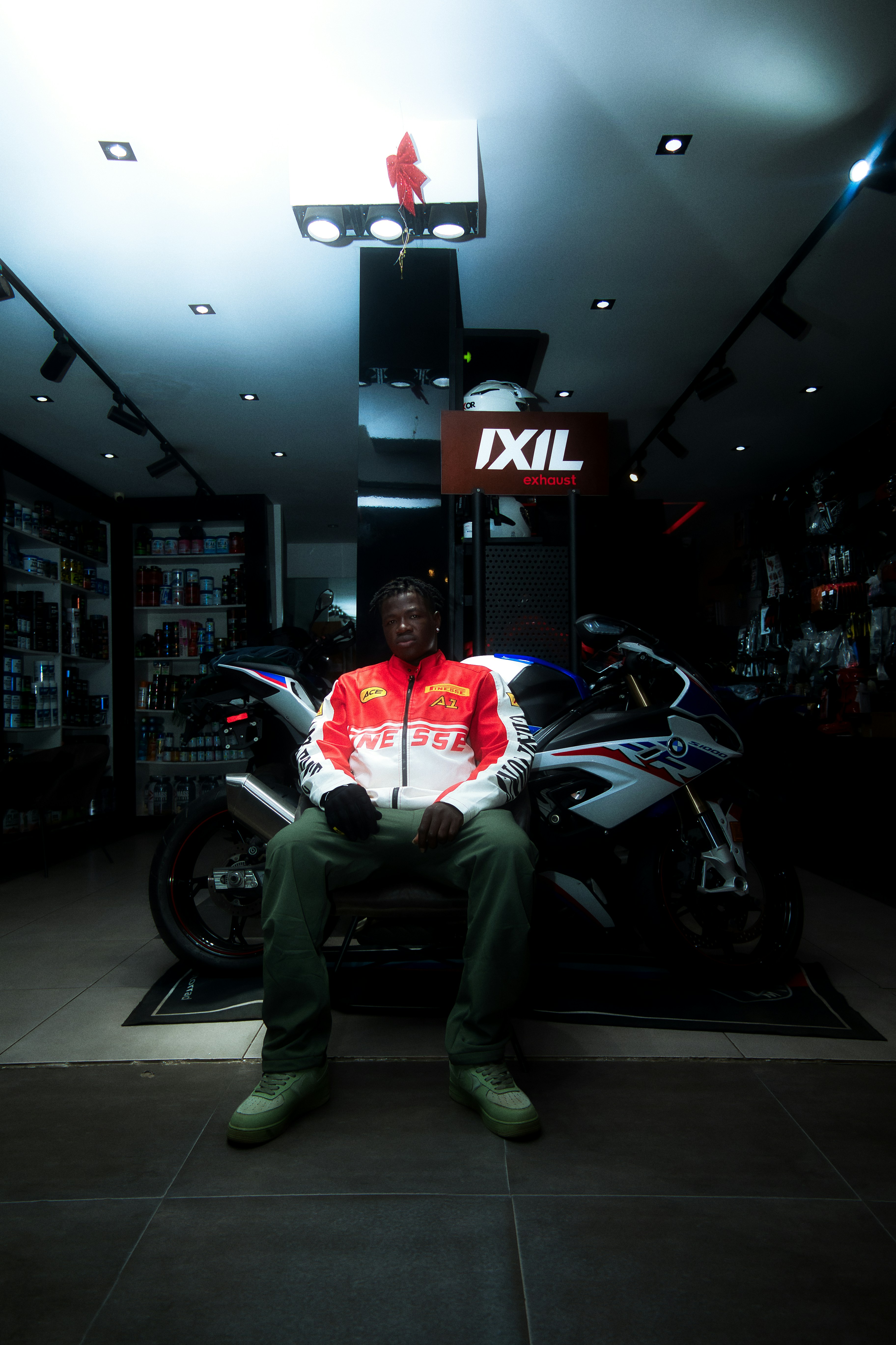 Man sitting in front of a motorcycle indoors.
