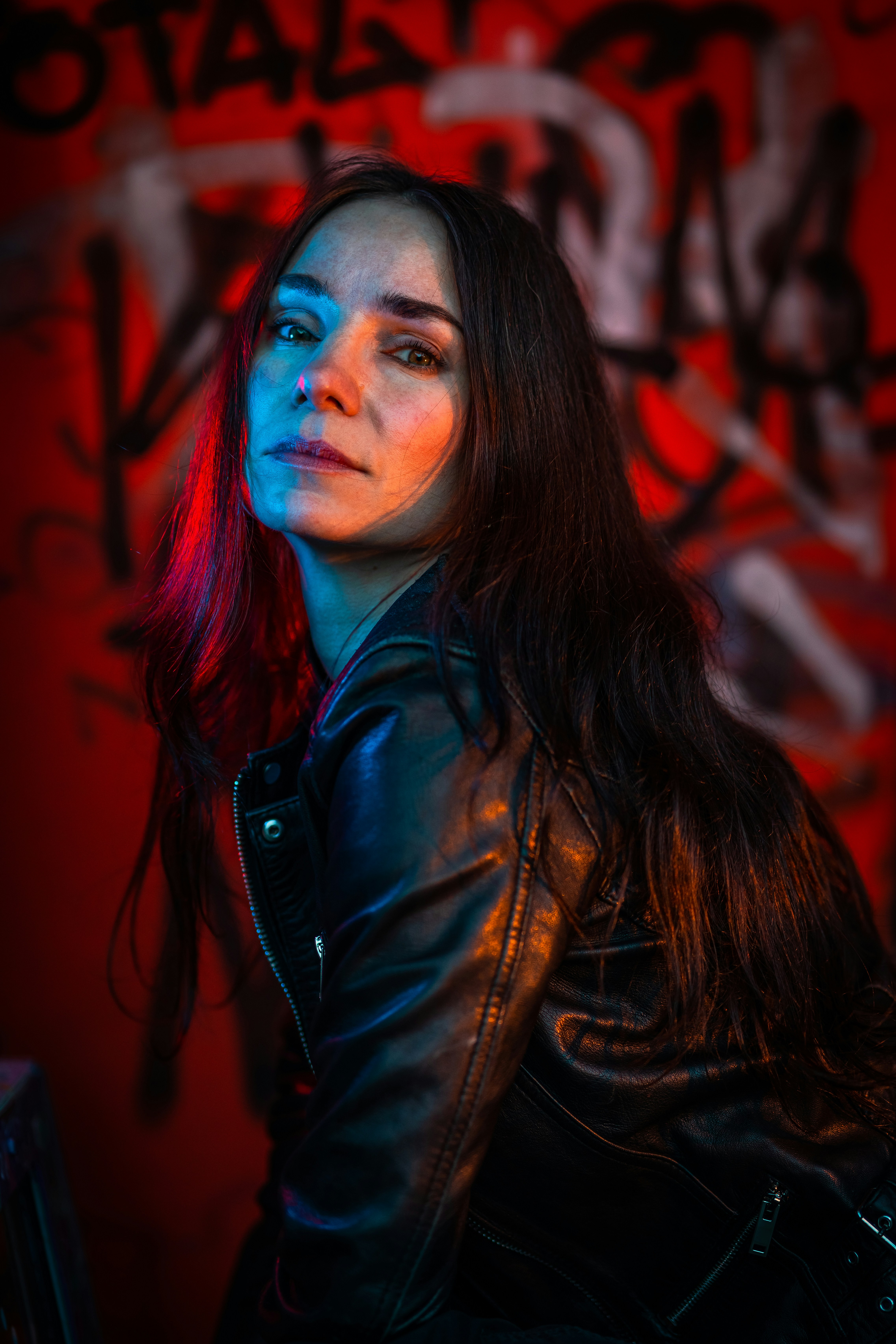 Woman in leather jacket with colorful lighting