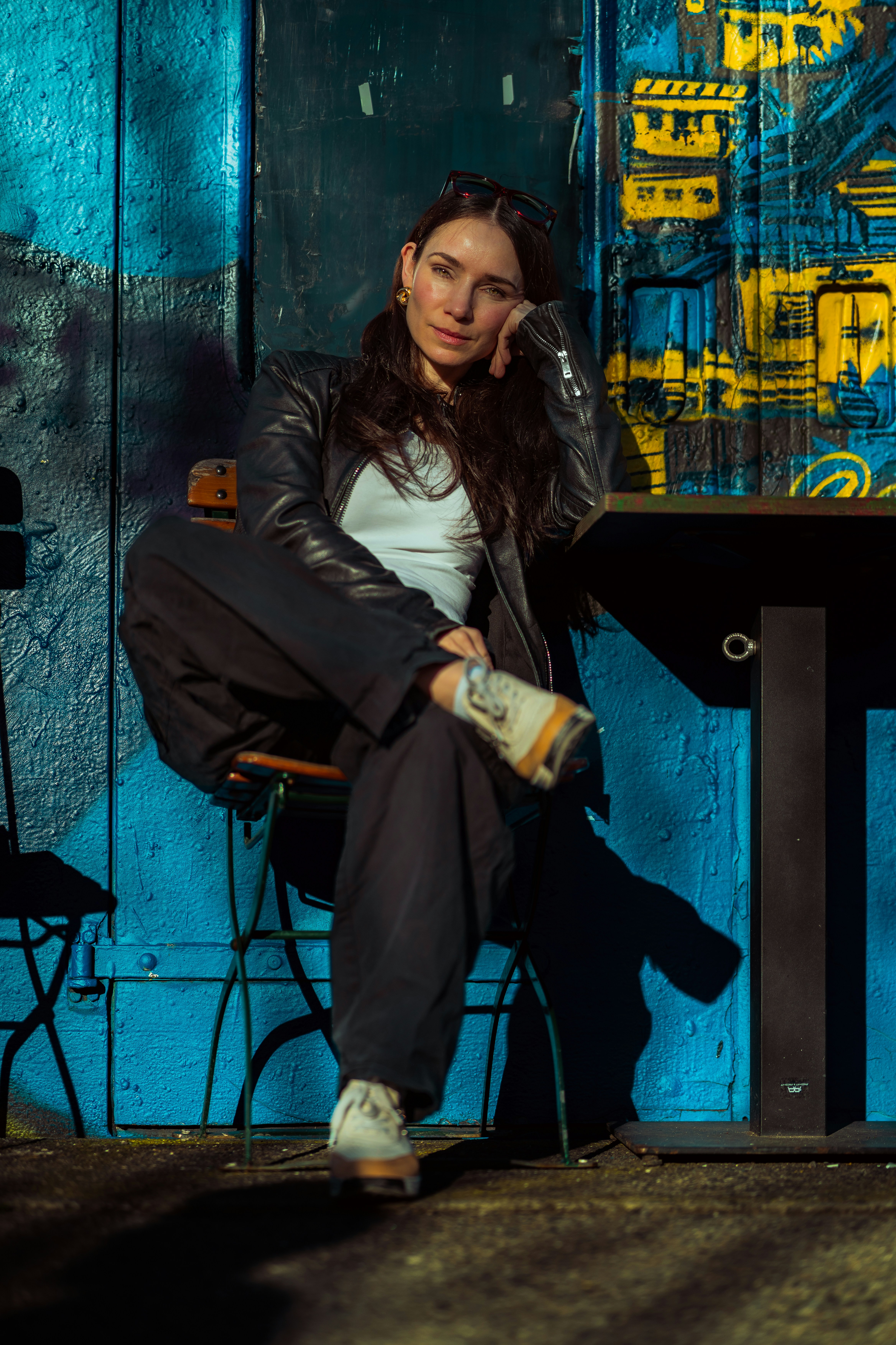 Woman sitting at a table with blue wall
