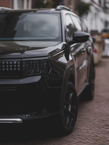 A black suv parked on a brick street.