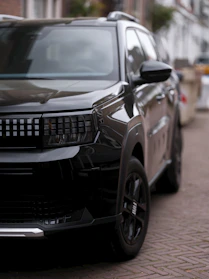 Black suv parked on a cobblestone street