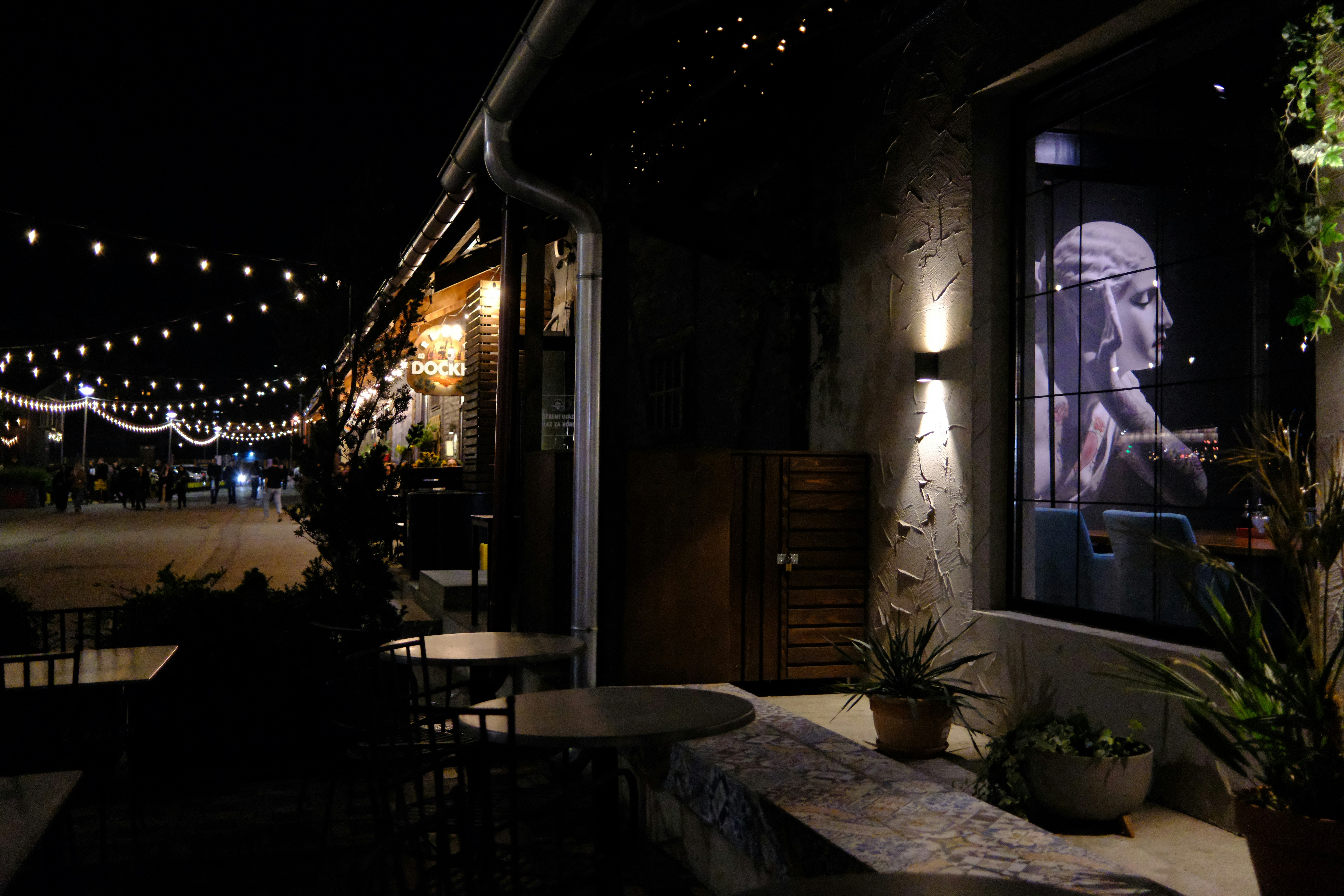 An outdoor terrace strung with lights in the evening
