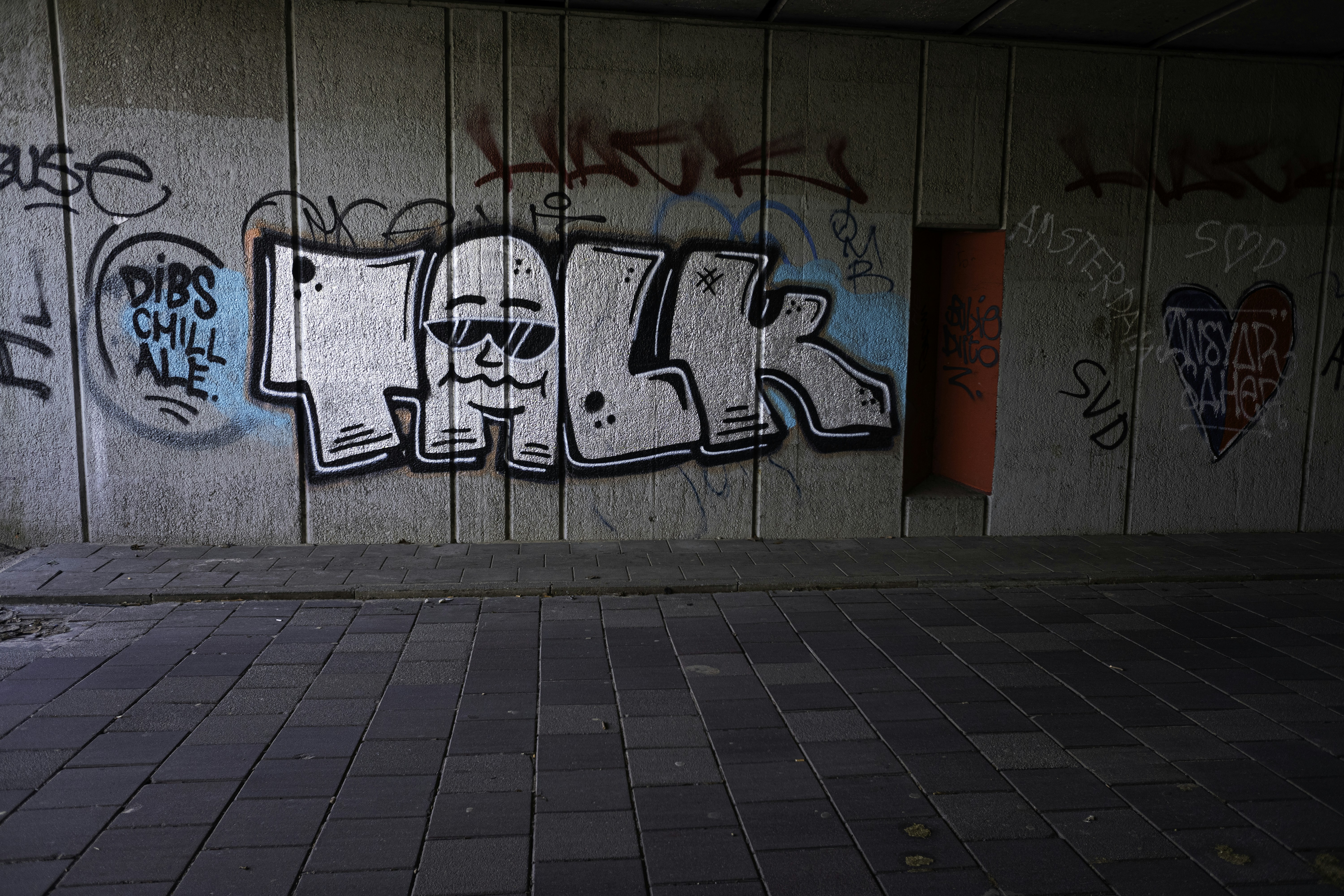 Graffiti art on a concrete wall with a doorway.