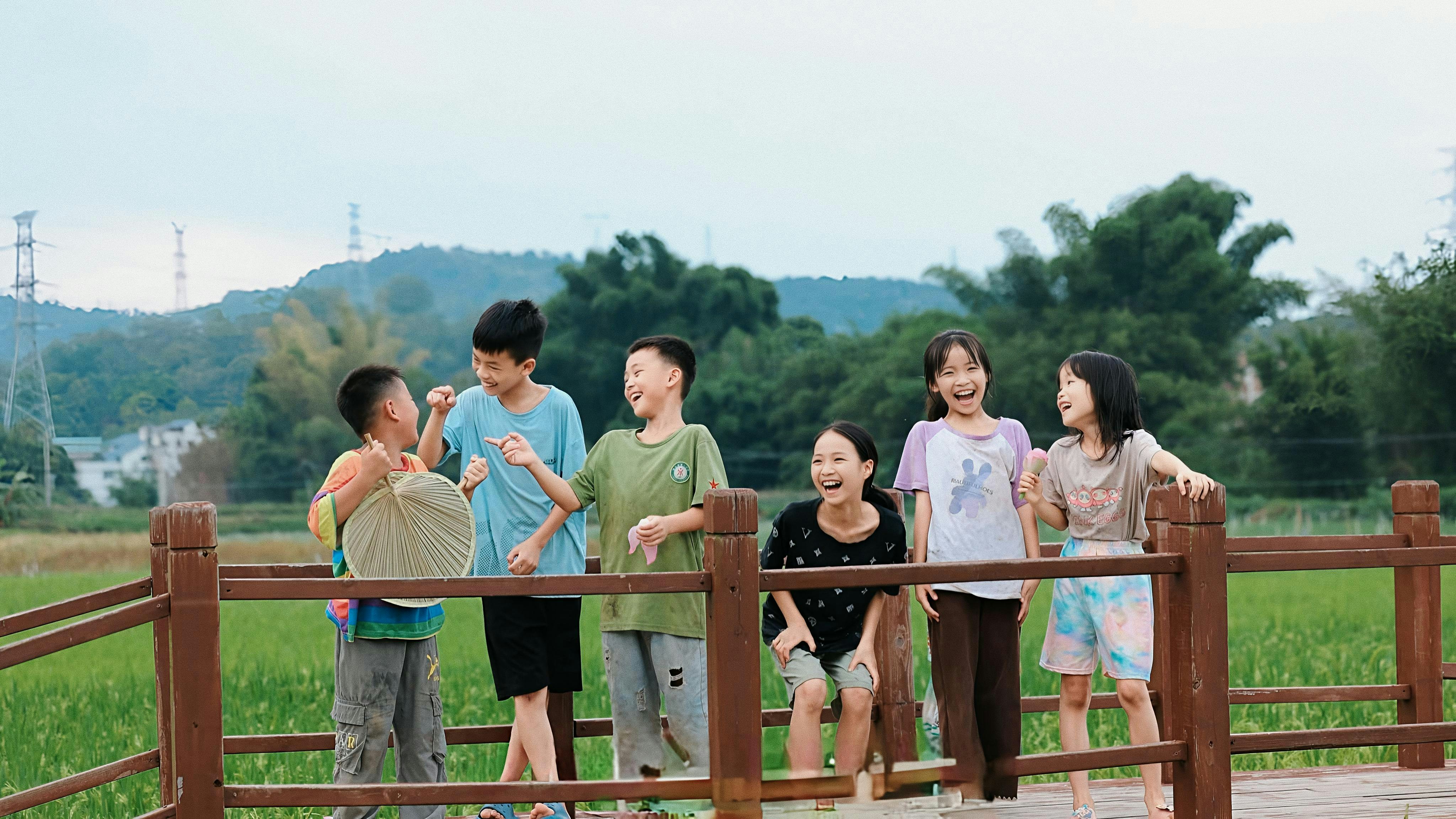 A group of children standing on a wooden bridge